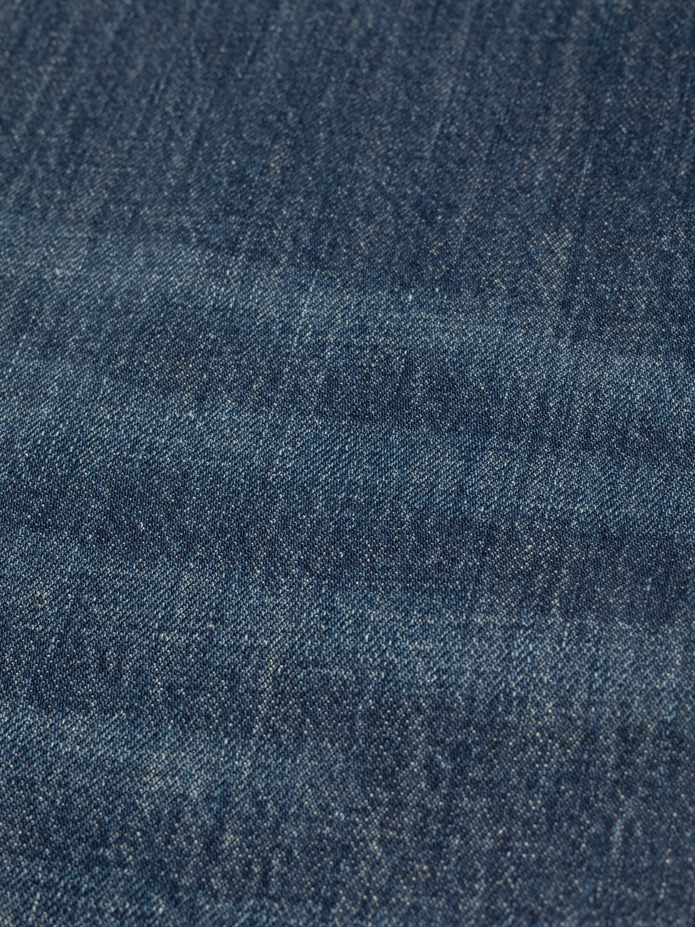 Nudie Jeans Steady Eddie II Indigo Dew, close-up of the blue rigid denim fabric texture.