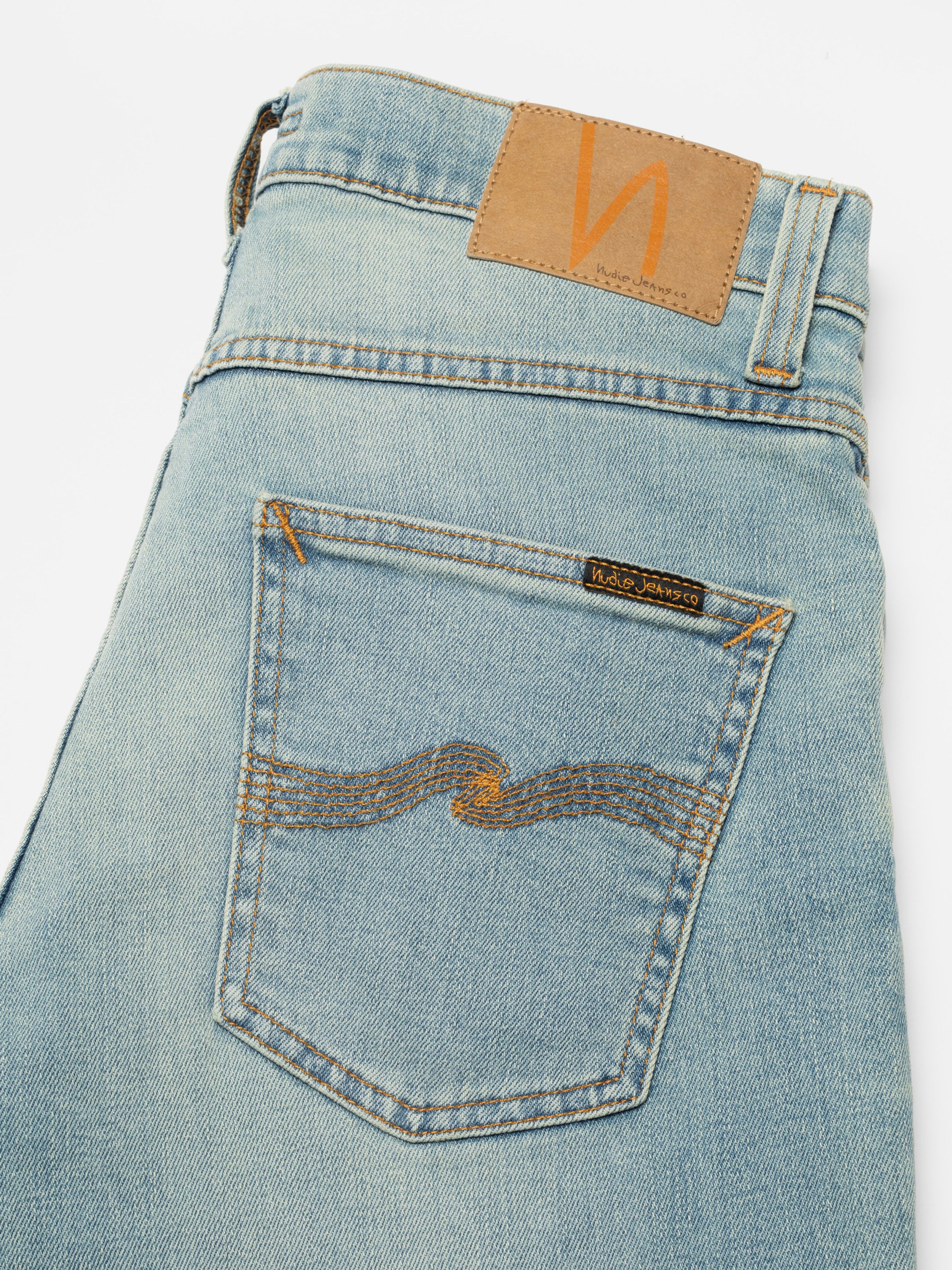 Nudie Jeans Grim Tim Shallow Waters, close-up of the back pocket with tobacco stitching and Jacron patch.