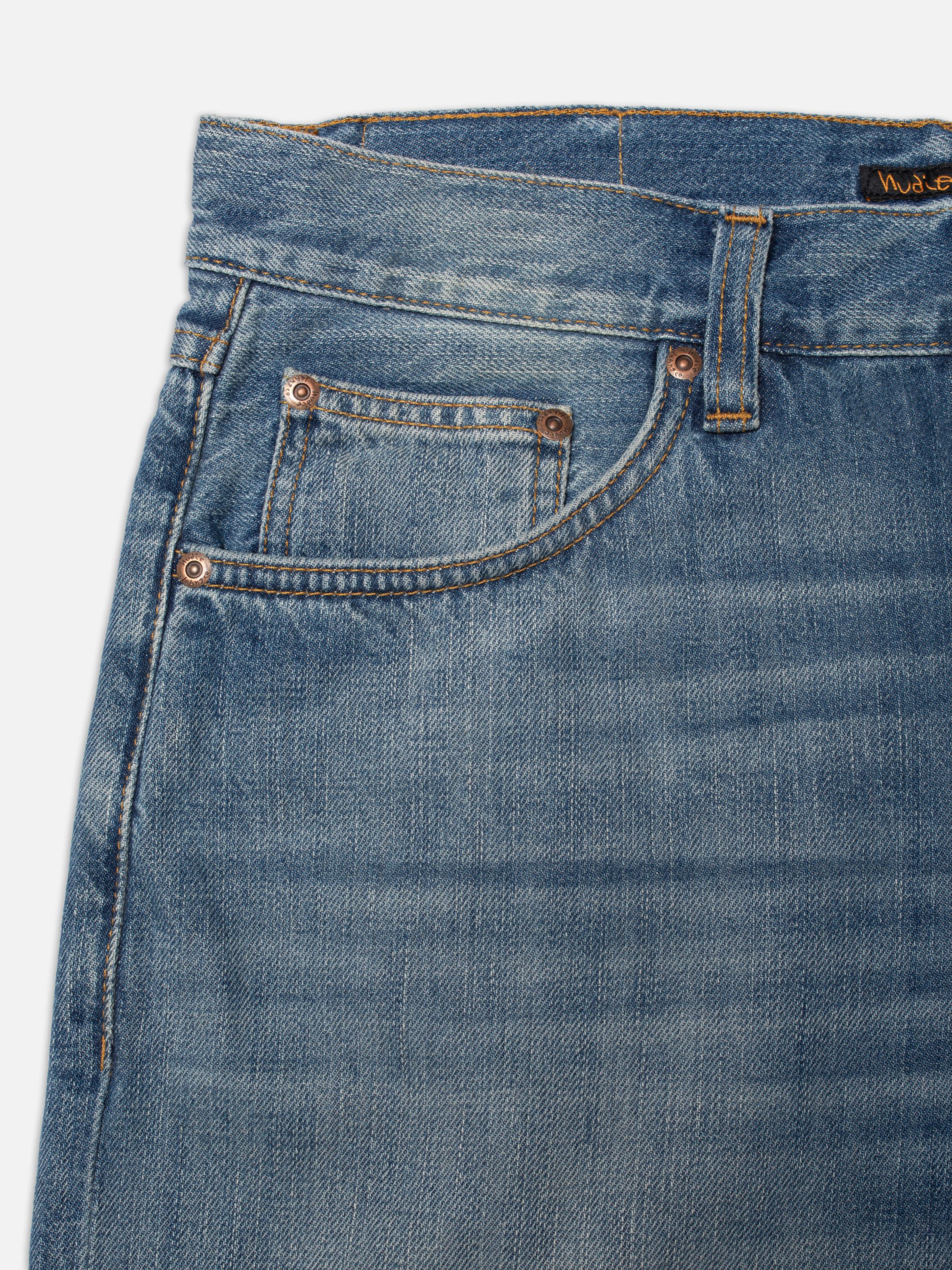 Nudie Jeans Rad Rufus Slow Drive, close-up of the front pocket and copper trims on these regular-fit blue jeans.