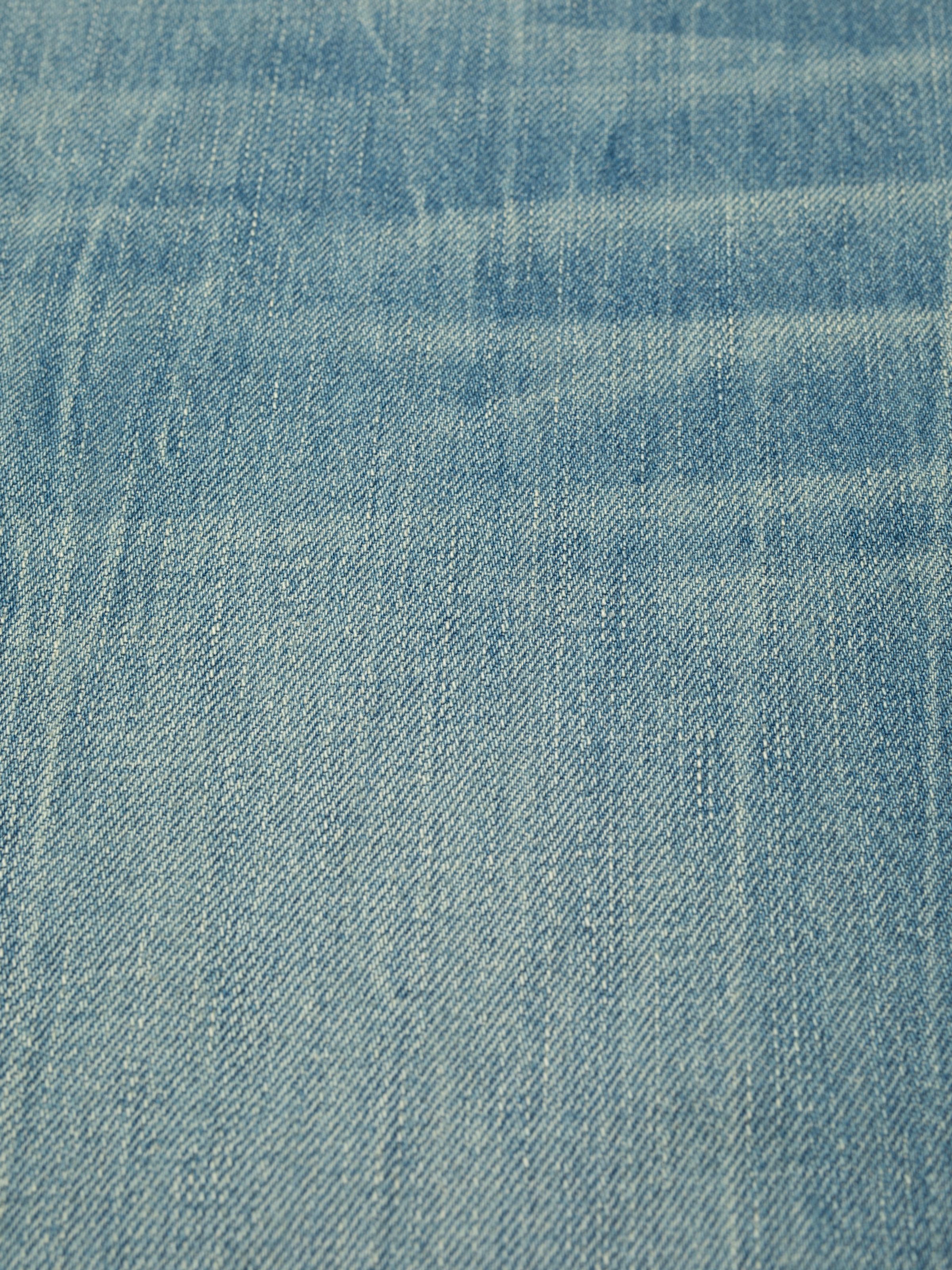 Nudie Jeans Tuff Tony Drift Wood, close-up of the light blue rigid denim fabric showing the twill texture.
