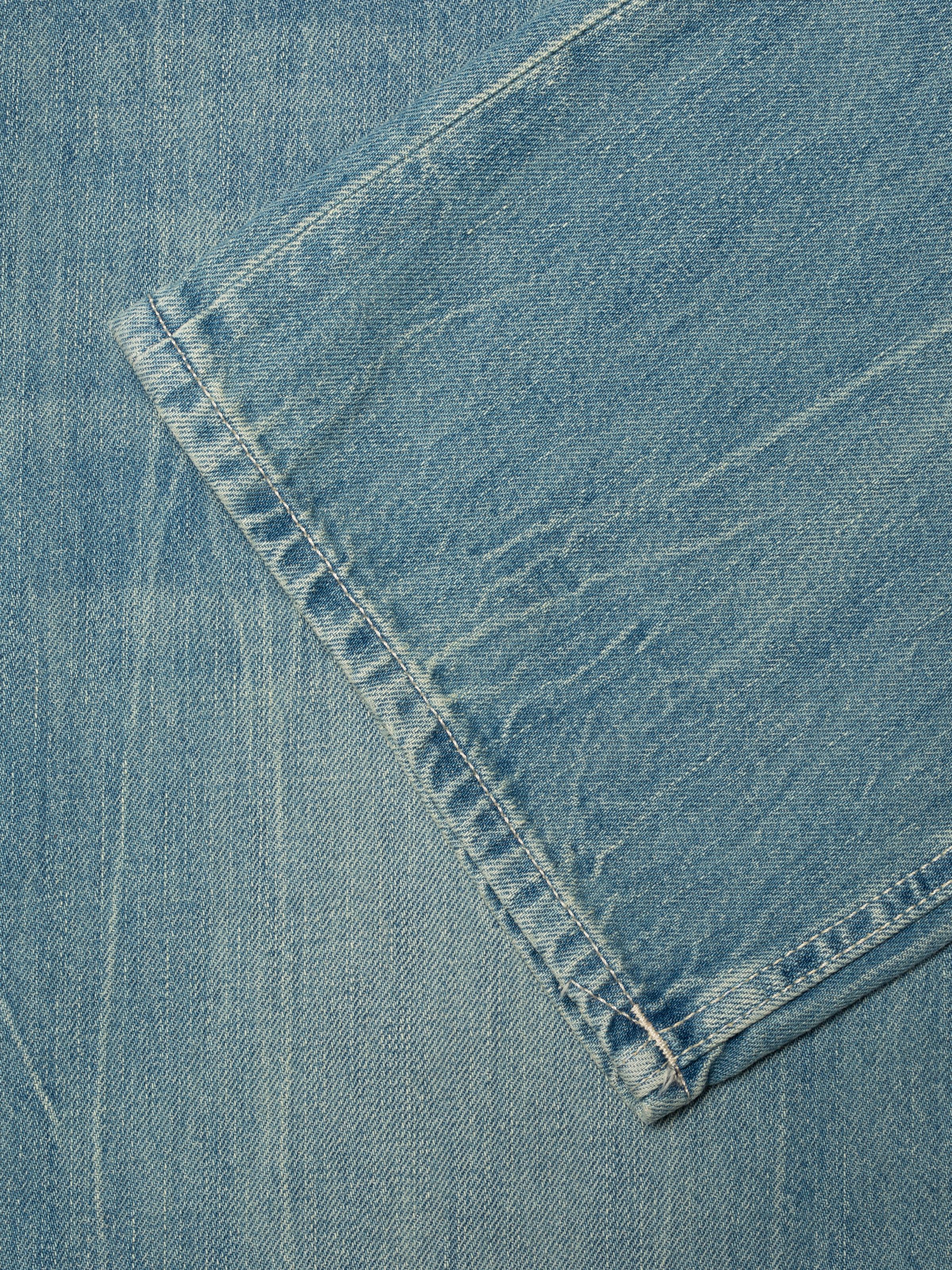 Nudie Jeans Tuff Tony Drift Wood, close-up of the light blue washed denim fabric and hem.