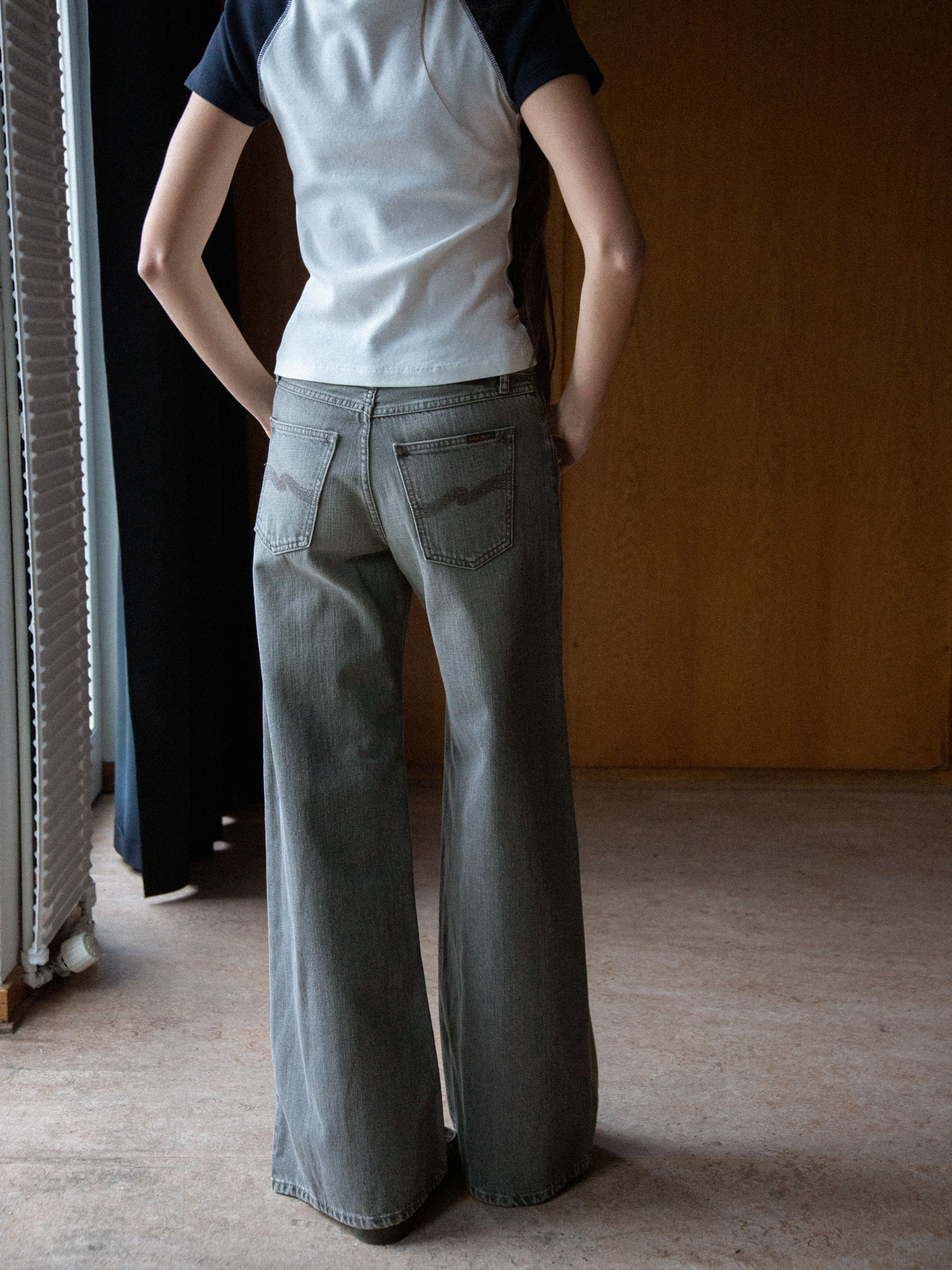 Nudie Jeans Sonic Sue Foggy Grey, women's loose-fit wide-leg jeans shown from the back on a model.