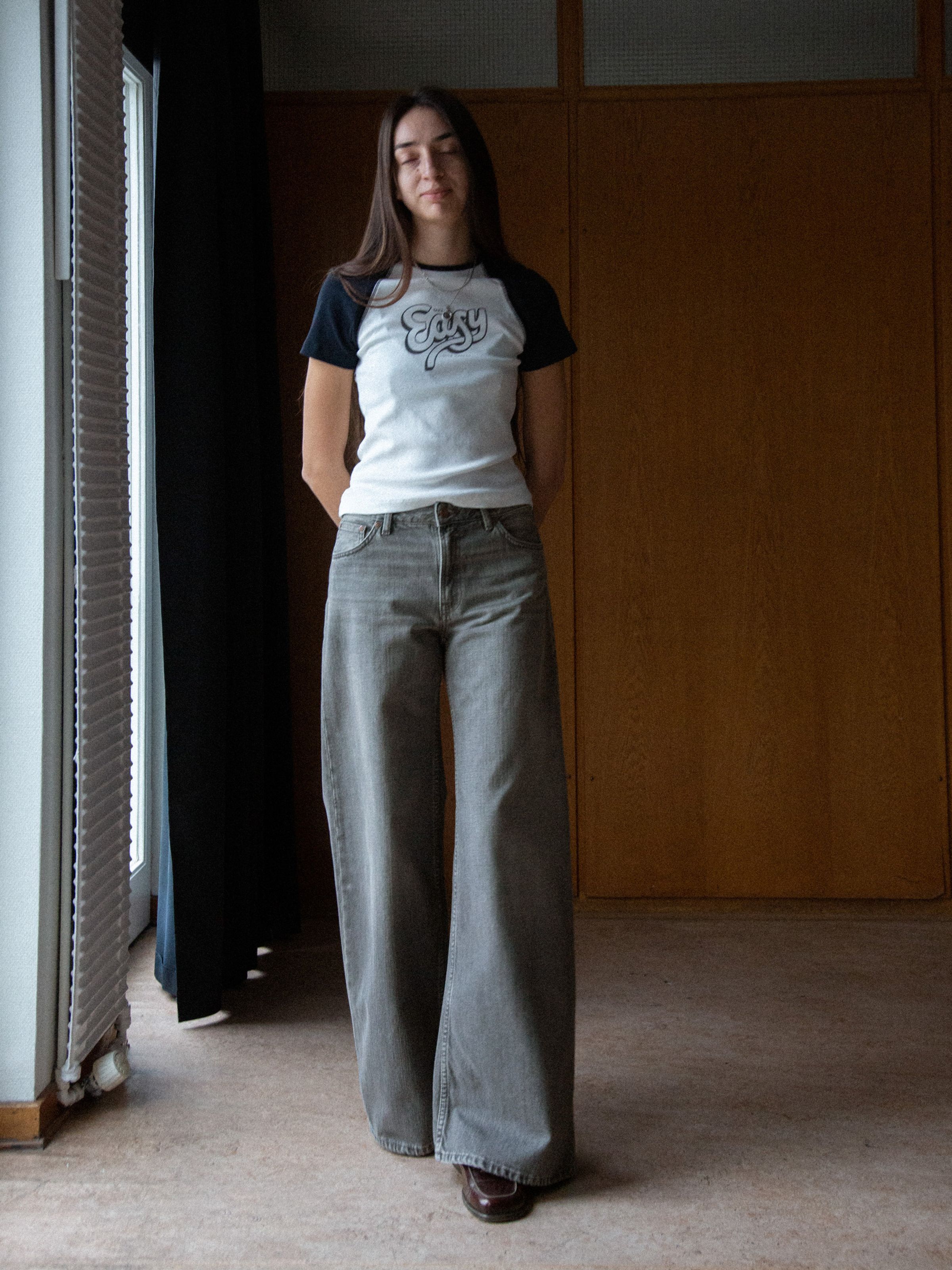 Nudie Jeans Sonic Sue Foggy Grey, women's loose-fit wide-leg jeans shown on a model in a lifestyle setting.