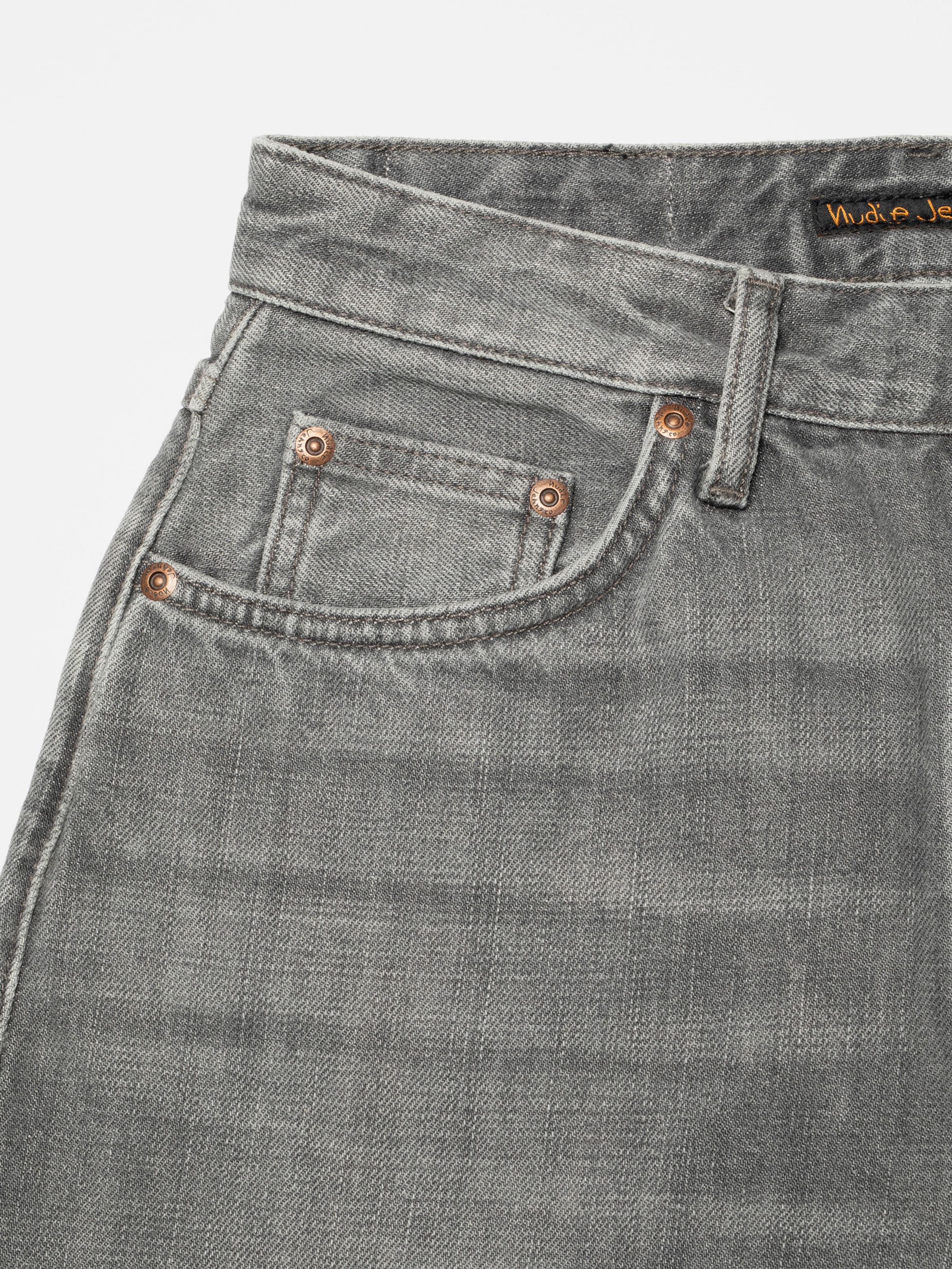 Nudie Jeans Clean Eileen Foggy Grey, close-up of the front pocket and copper rivets on grey denim.