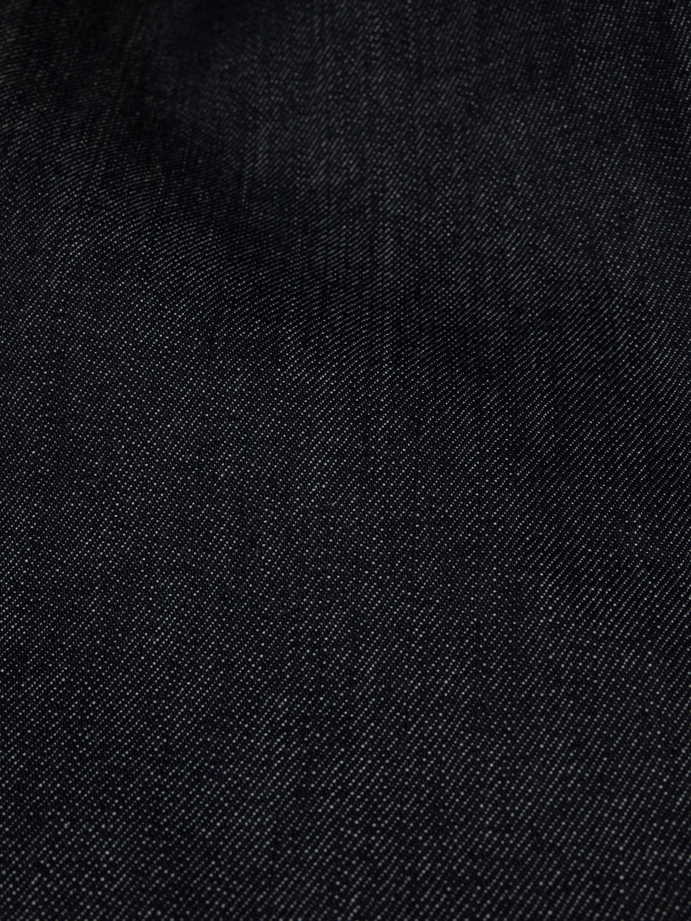 Nudie Jeans Flare Glenn Dry One, close-up showing the texture of the 13.5 oz. rigid organic cotton denim in Dry Blue.