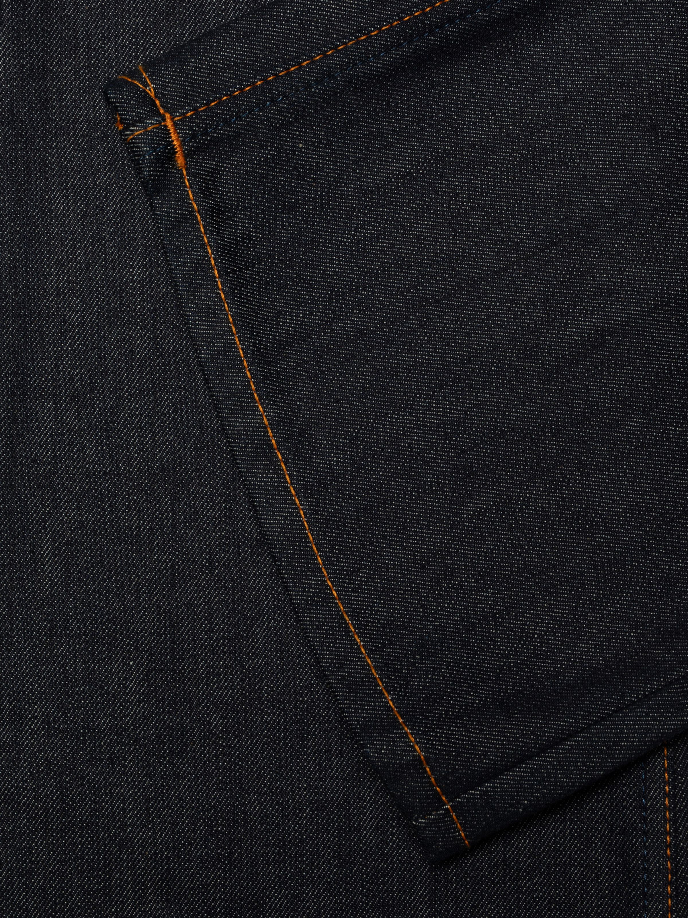 Nudie Jeans Flare Glenn Dry One, close-up of the rigid dry indigo denim and orange thread at the seams.