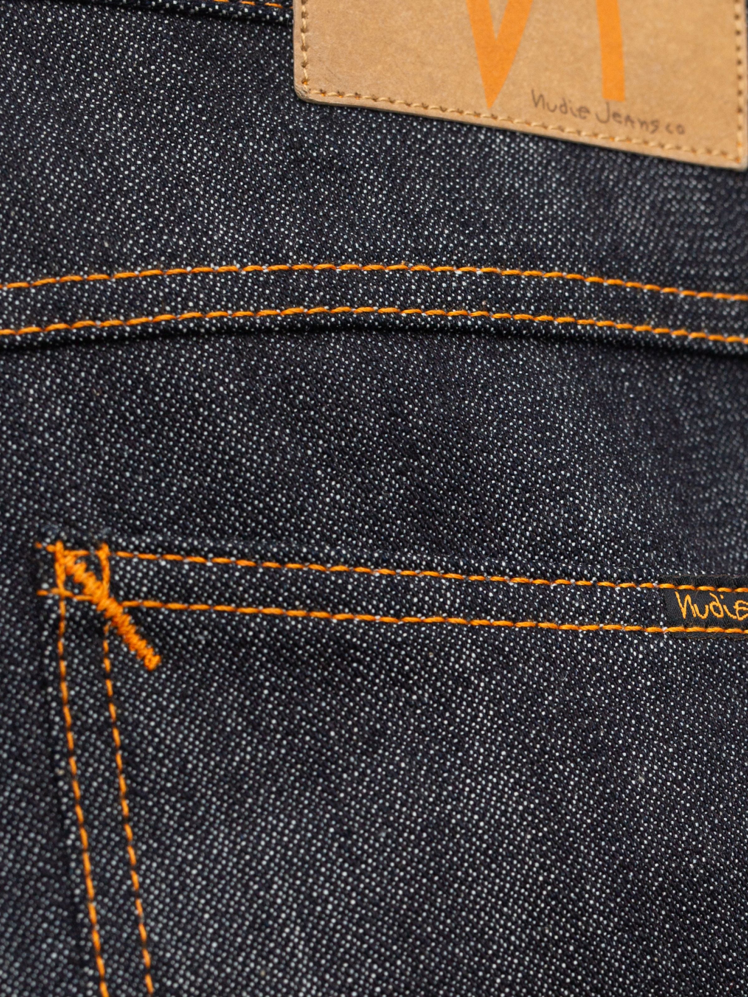 Nudie Jeans Slim Jim Dry Two back pocket detail with orange thread on dark indigo organic cotton rigid denim.