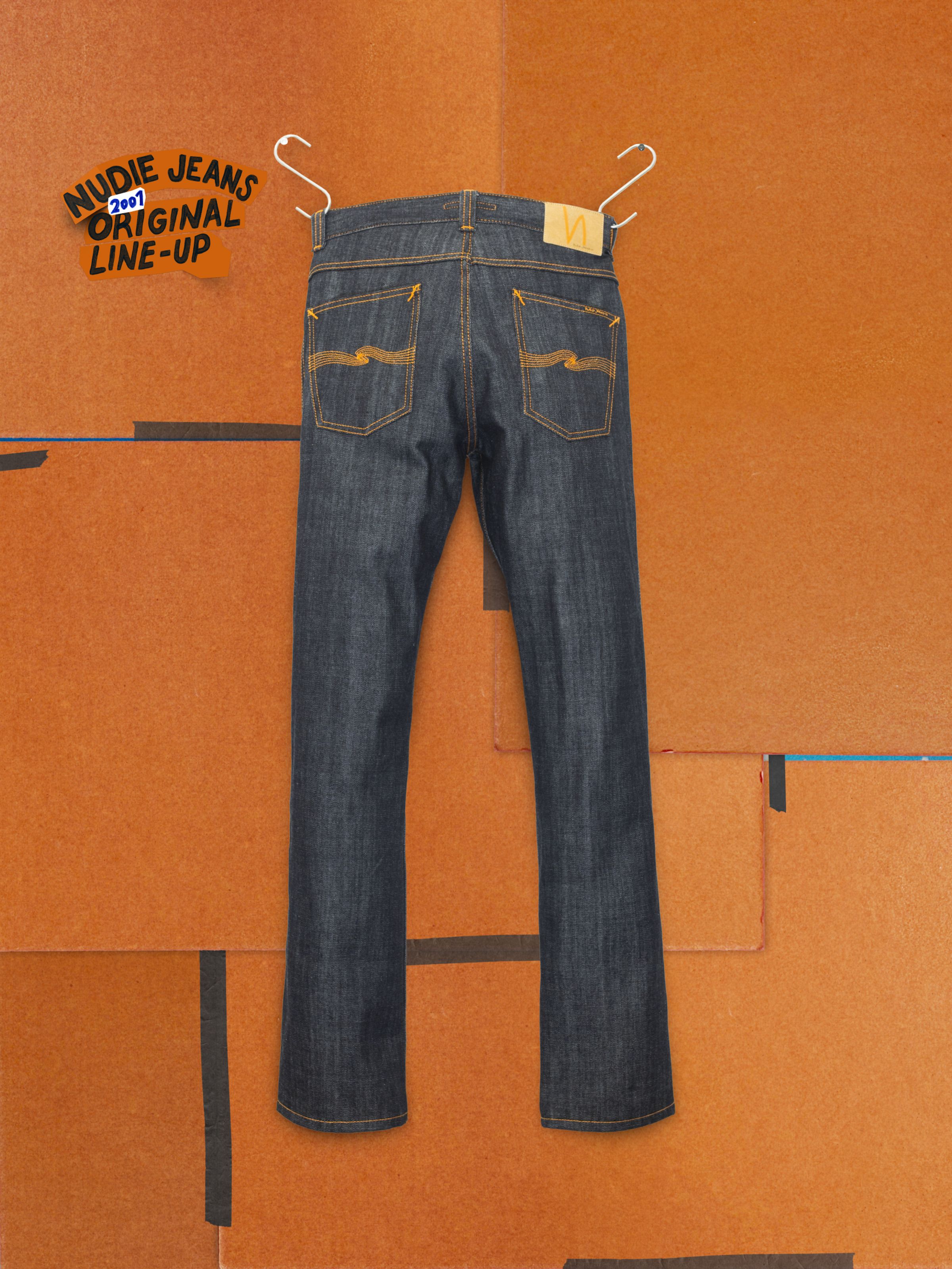 Nudie Jeans Slim Jim Dry Two, slim-fit rigid denim jeans in Dry Blue, shown from the back against an orange background.