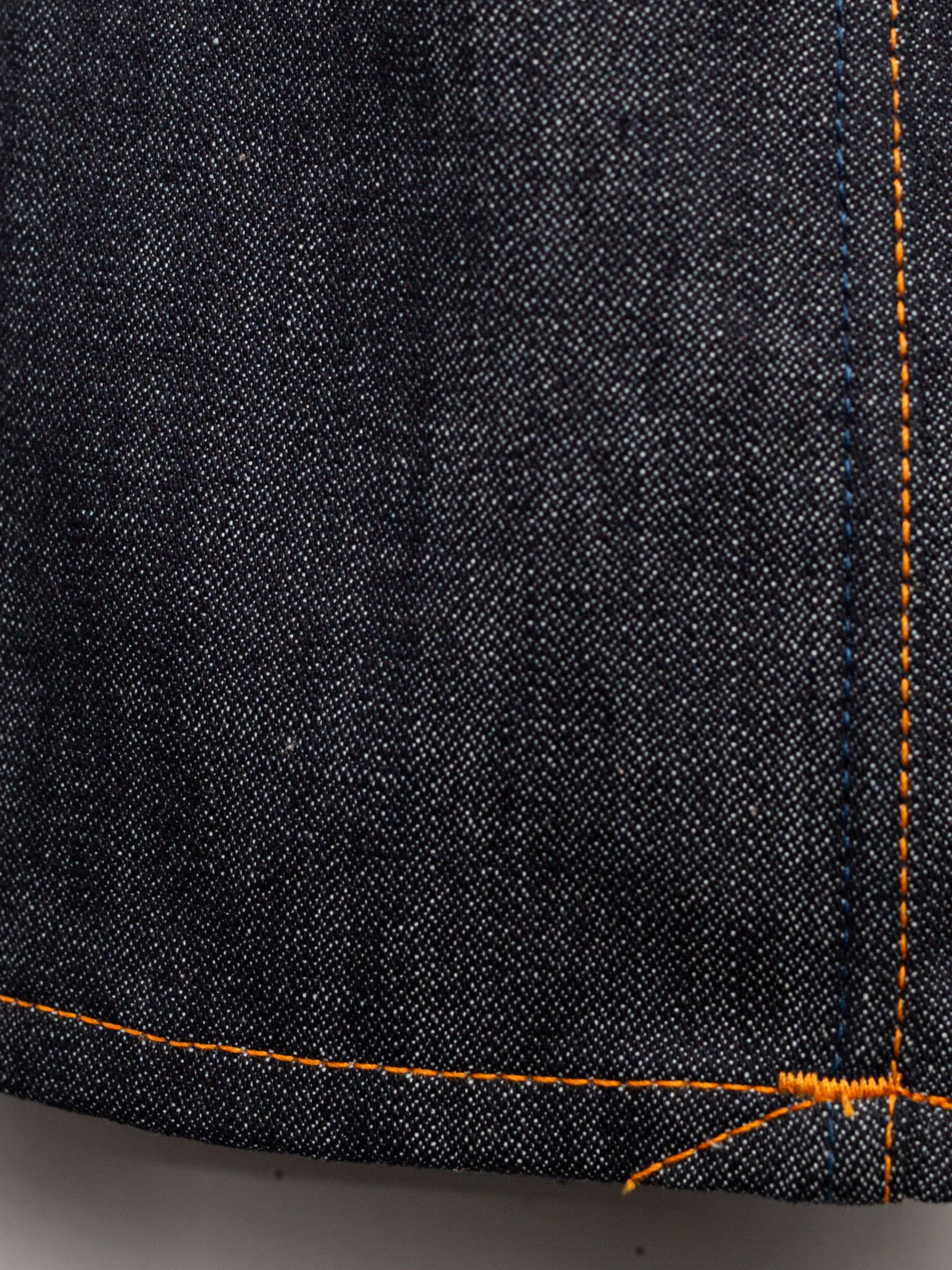 Nudie Jeans Slim Jim Dry Two, showing the dark indigo rigid organic cotton broken twill denim and orange topstitching.