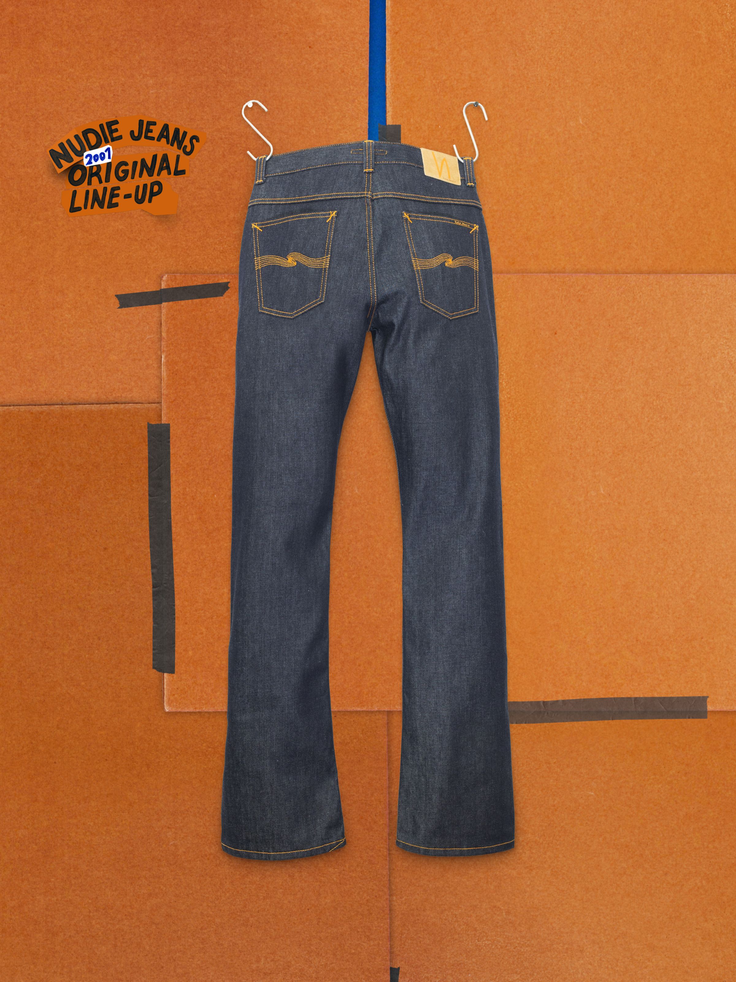 Nudie Jeans Regular Alf Dry One, men's rigid bootcut jeans in dry blue denim, back view with orange seams and Jacron patch.