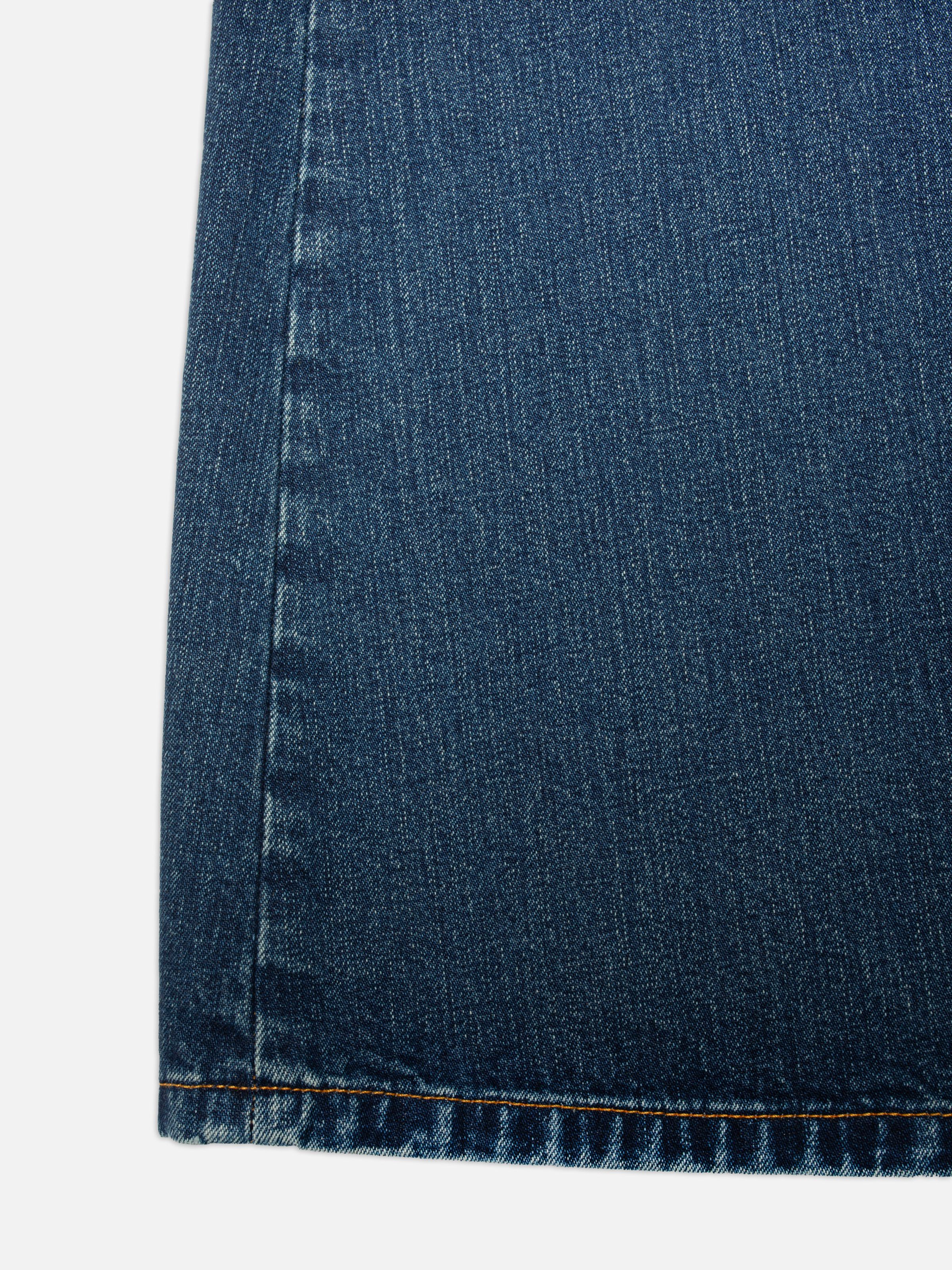 Nudie Jeans Tanja Skirt Orange Painter, close-up of the mid-blue rigid denim and orange thread on the seams.