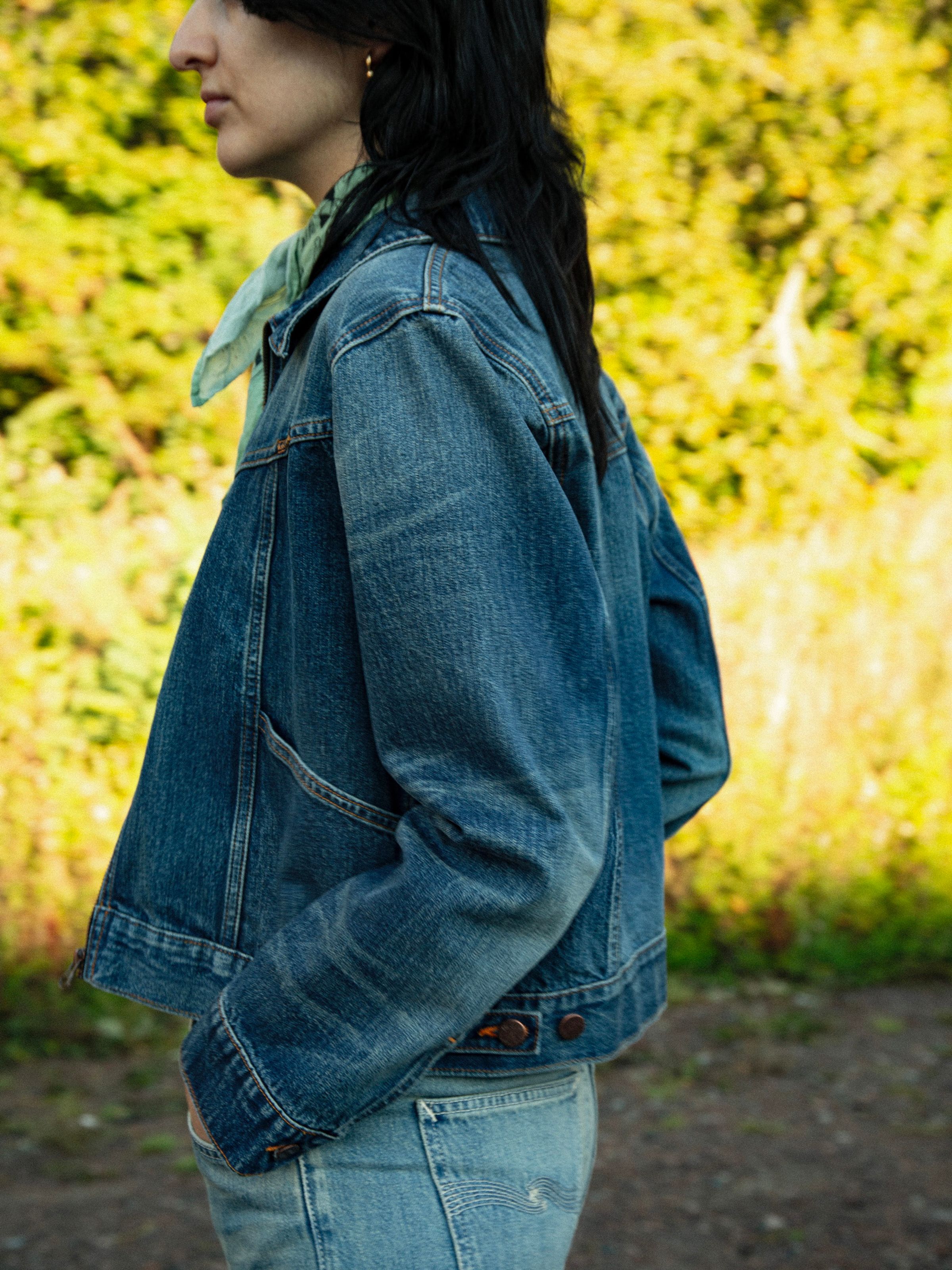 Nudie Jeans Britta Jacket Orange Painter, women's mid-blue denim jacket shown from the side on a model.
