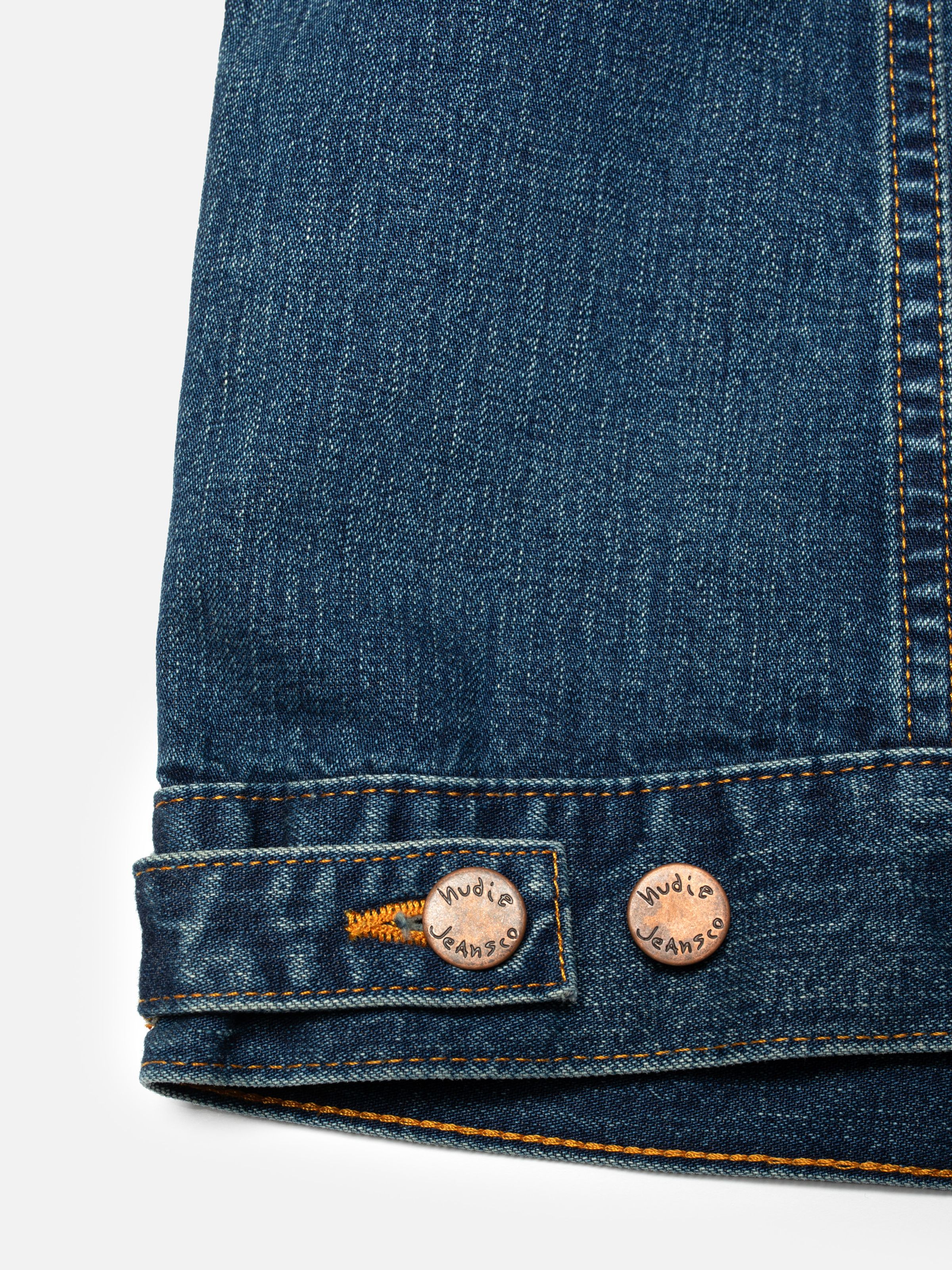 Nudie Jeans Britta Jacket Orange Painter, close-up of the copper buttons and orange stitching at the hem.
