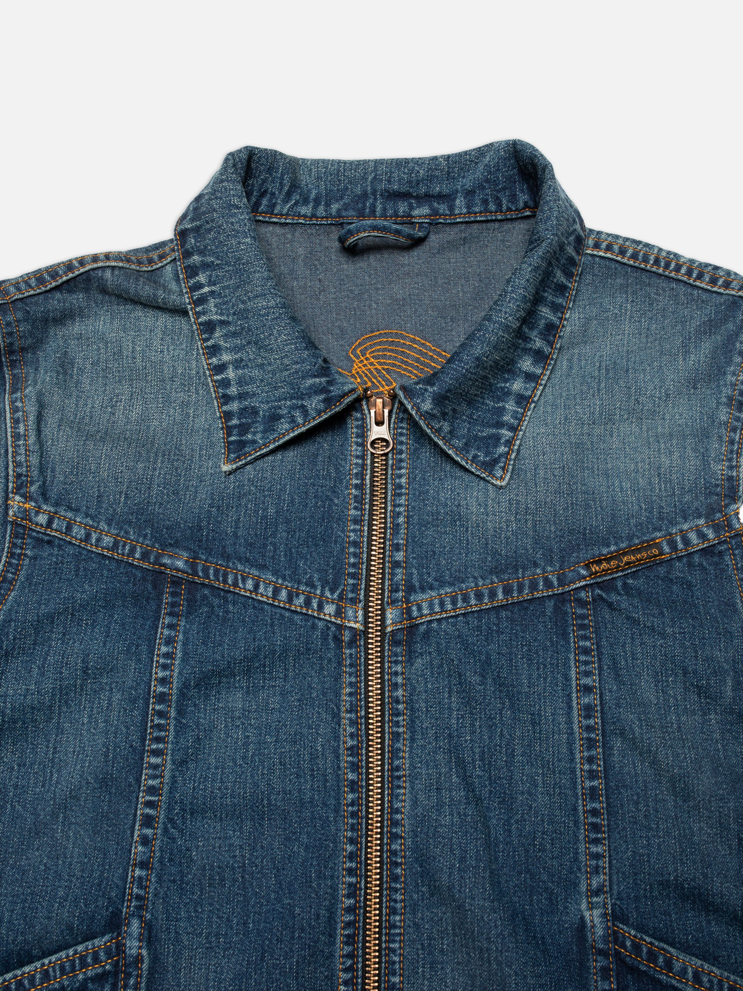 Nudie Jeans Britta Jacket Orange Painter, close-up of the collar and copper zipper on a mid-blue wash denim jacket.