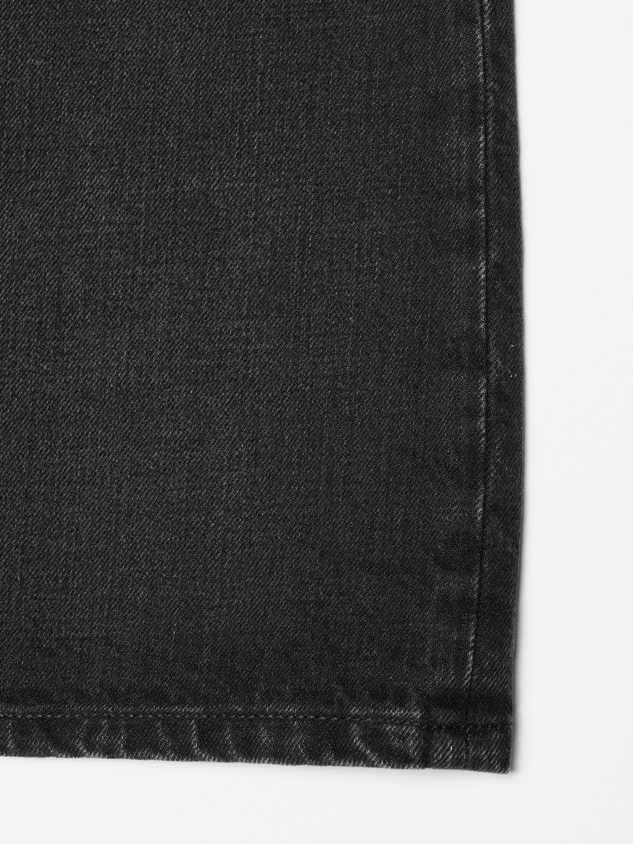Nudie Jeans Meja Denim Shorts Night Dune, close-up of the black washed denim fabric showing the texture.