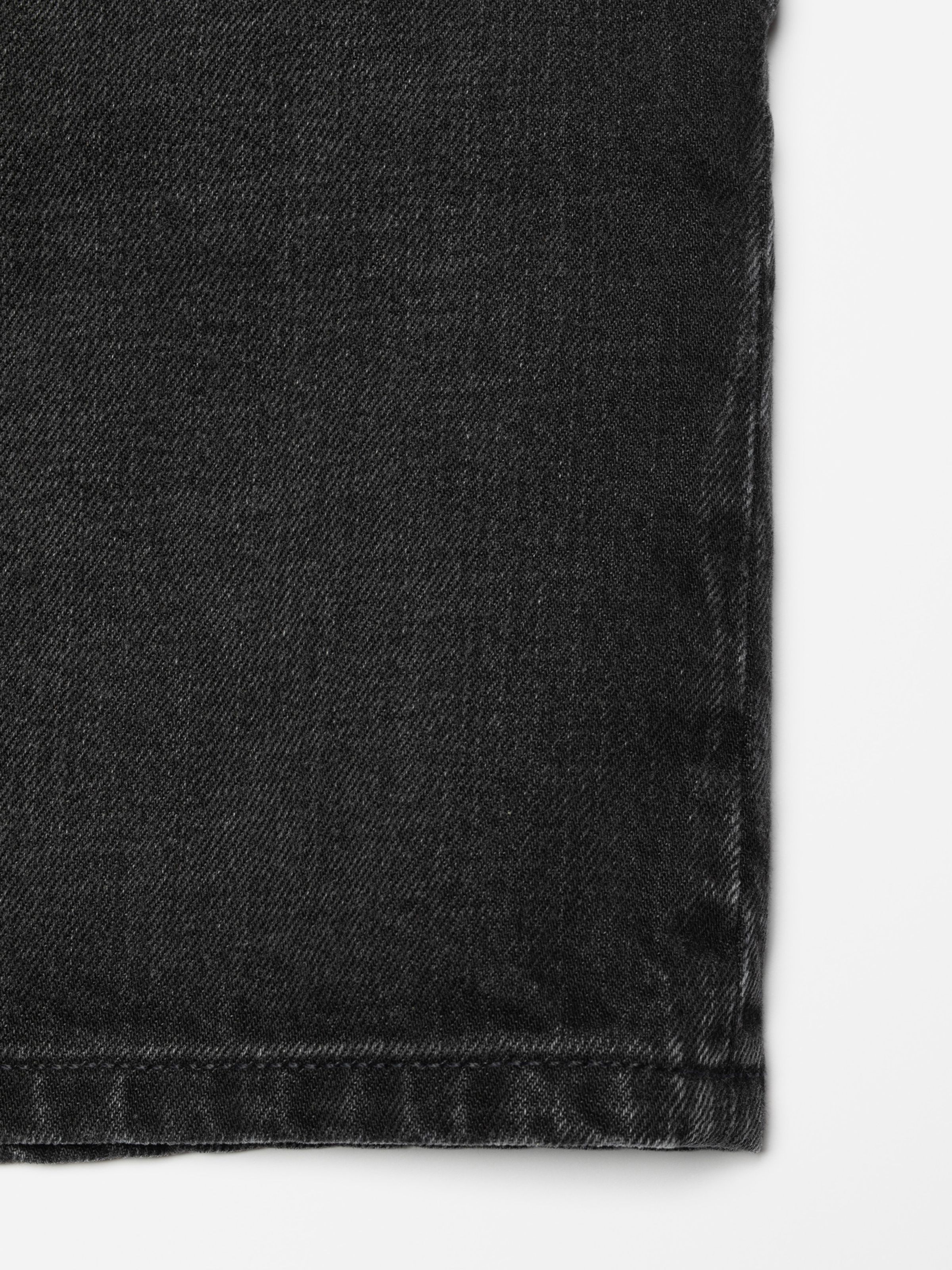 Nudie Jeans Seth Denim Shorts Night Dune, close-up of the black denim fabric texture.
