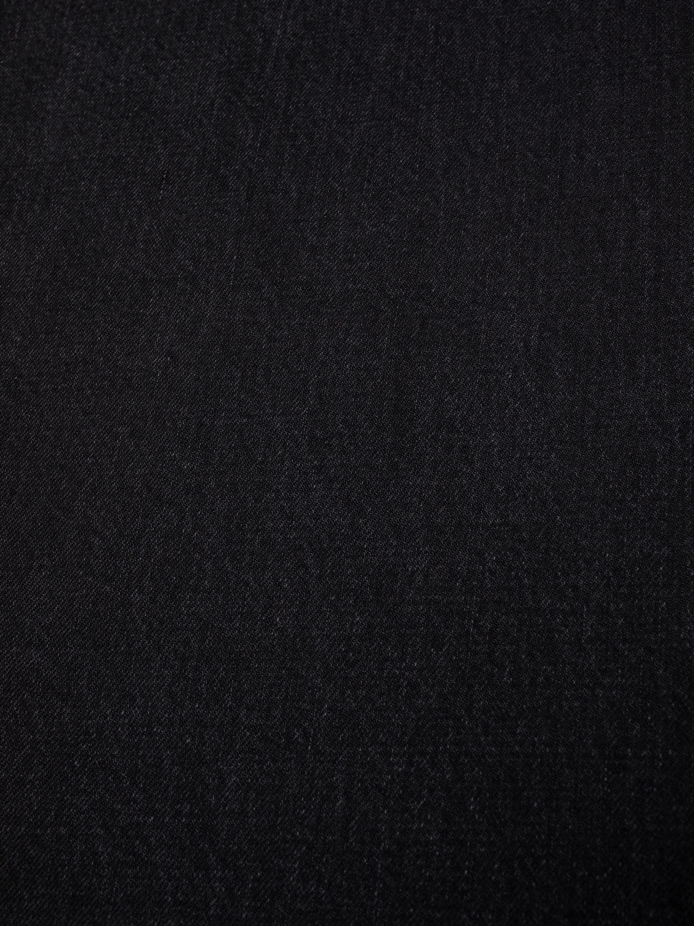 Nudie Jeans Sonic Sue Friendly Black, women's loose A-line jeans, showing a close-up of the washed black rigid denim.