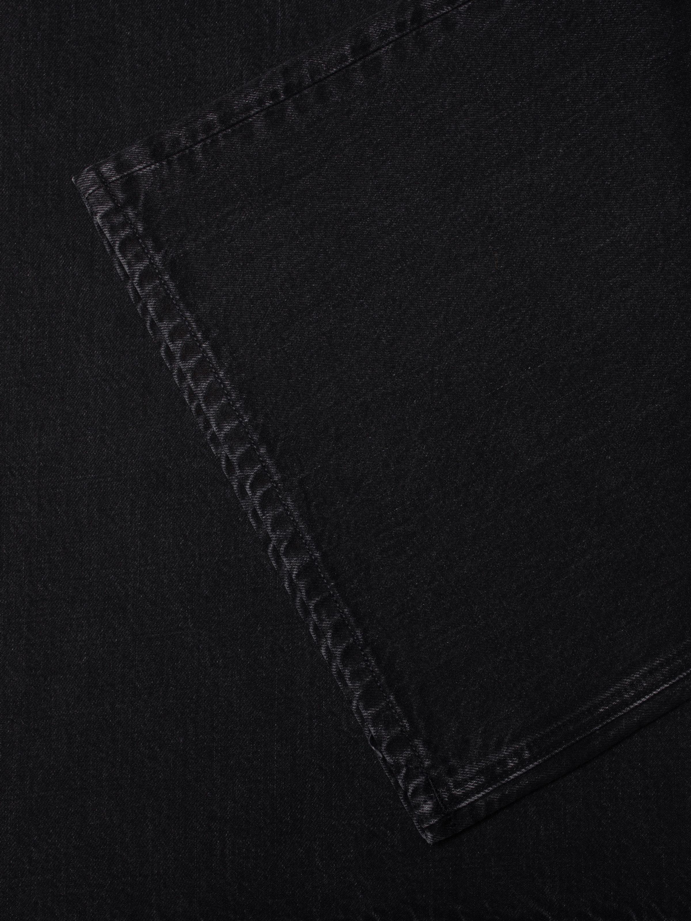 Nudie Jeans Sonic Sue Friendly Black, women's wide A-line leg jeans, showing a close-up of the hem stitching detail.