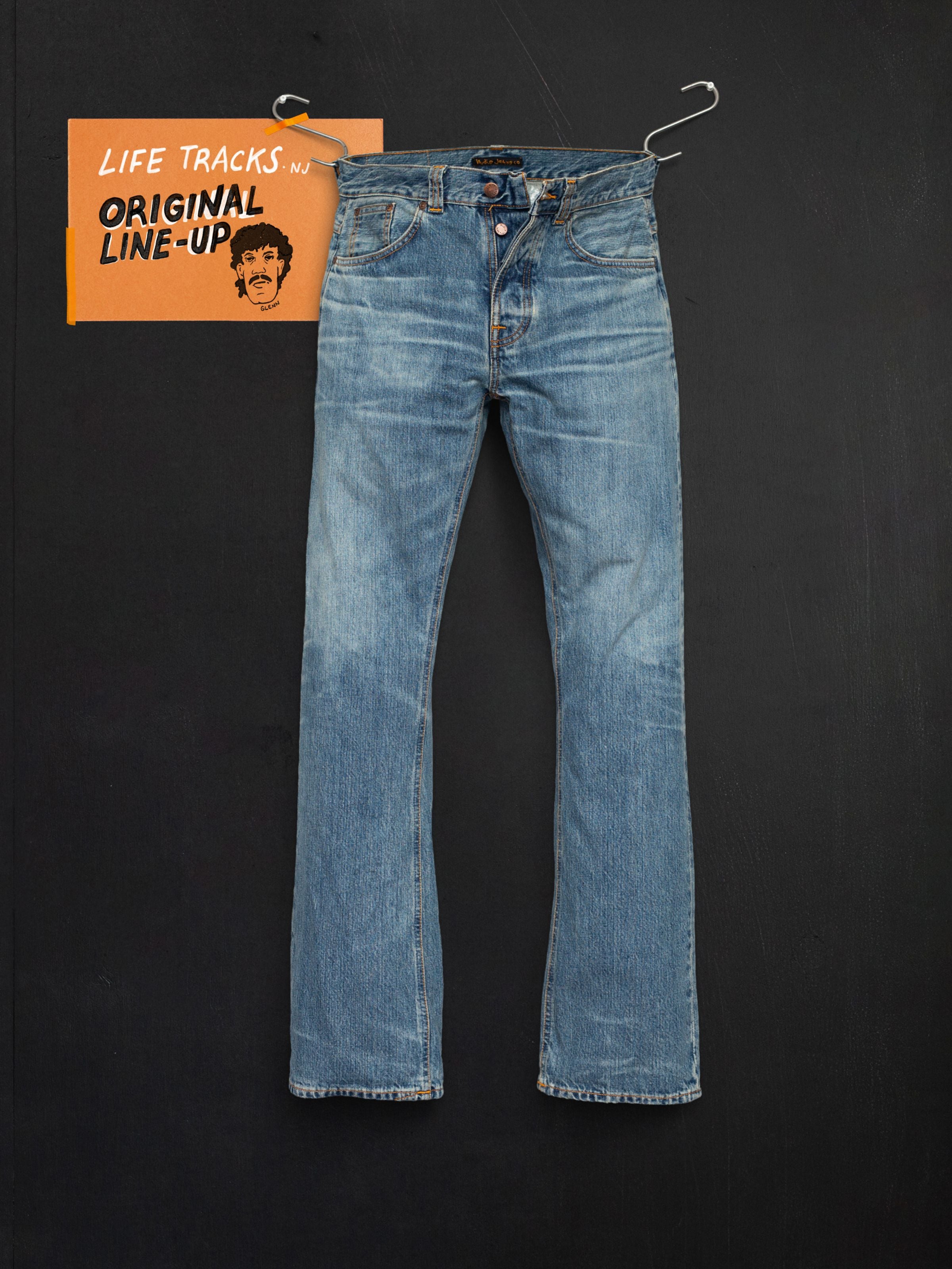 Nudie Jeans Regular Alf Silver Tracks, mid blue washed rigid denim bootcut jeans, laid flat on a black background.
