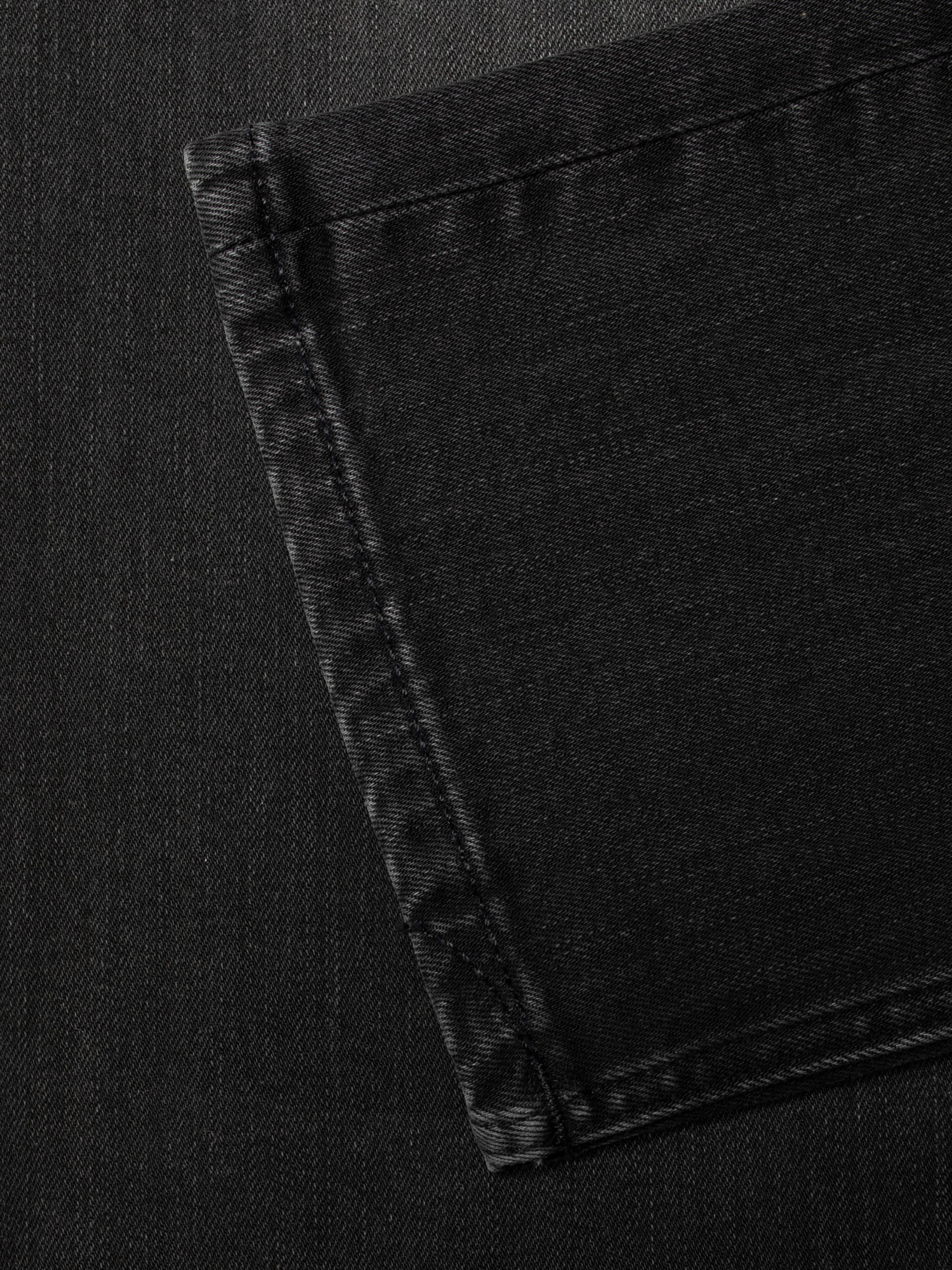 Nudie Jeans Grim Tim Black Mist, men's slim fit jeans, close-up of the back pocket detail showing the black stitching.
