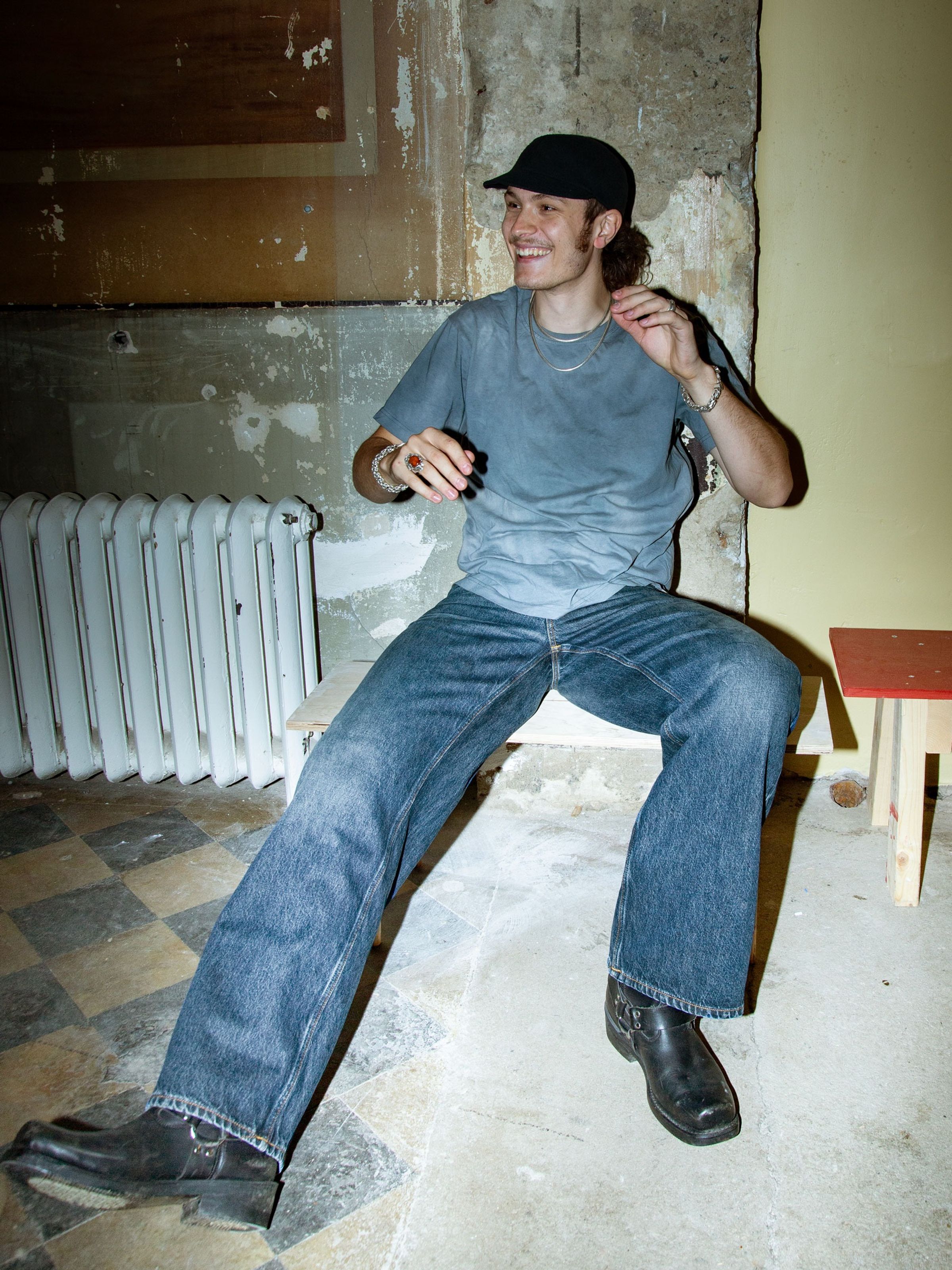 Nudie Jeans Loud Larry Electric Blues, men's loose fit wide-leg jeans, shown on a model sitting on a bench.