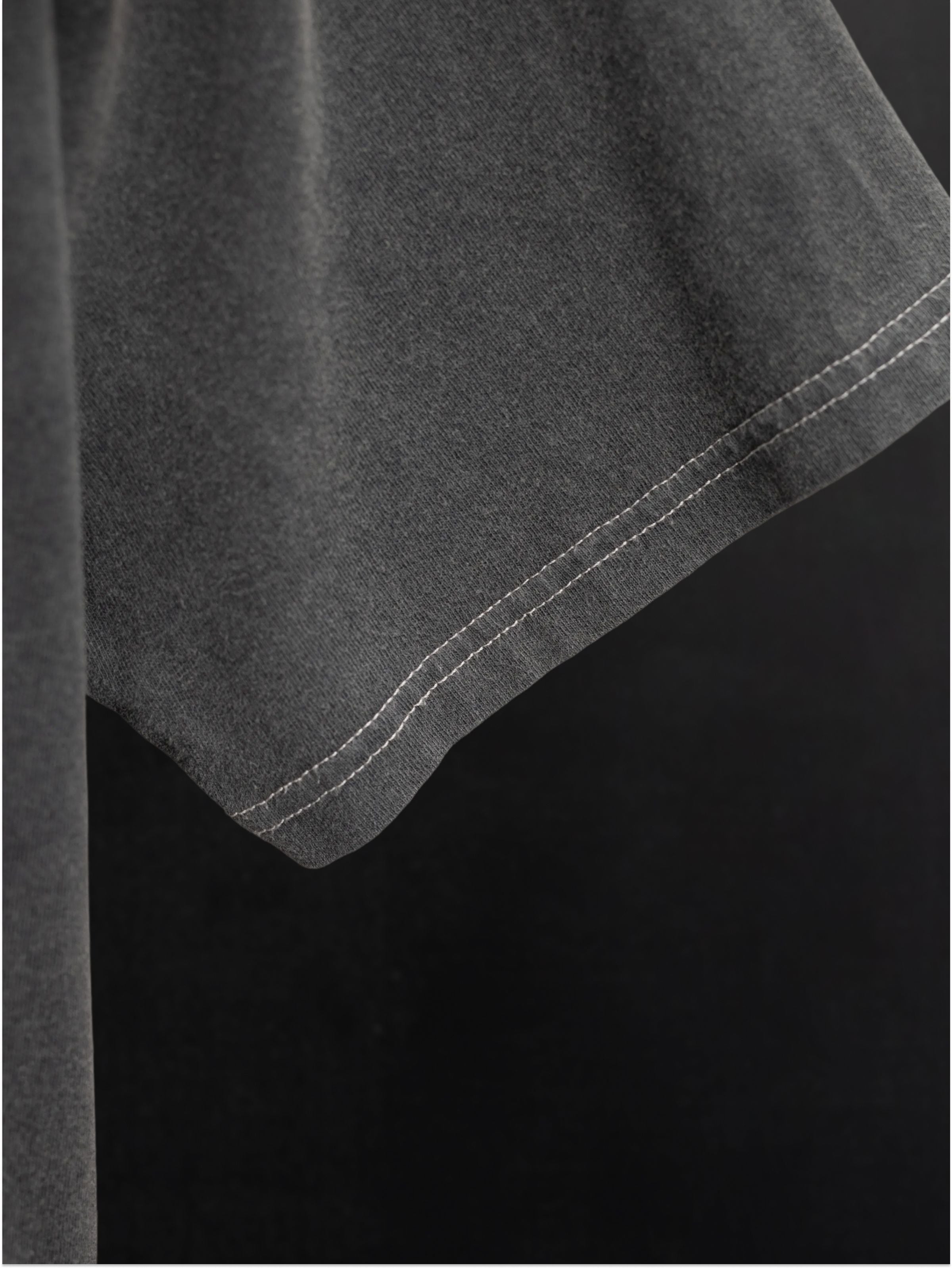 Nudie Jeans Koffe T-Shirt LifeTracks III Antracite, a close-up of the garment-dyed organic cotton sleeve and stitching.