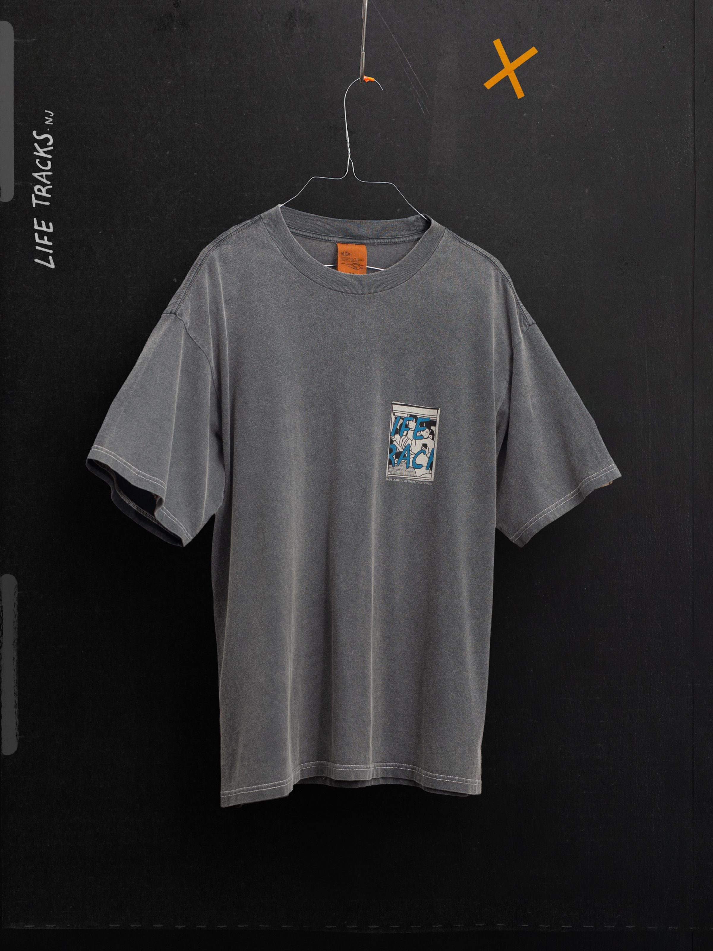Nudie Jeans Koffe T-Shirt LifeTracks III Antracite, a faded organic cotton tee with chest print hanging on a wire hanger.