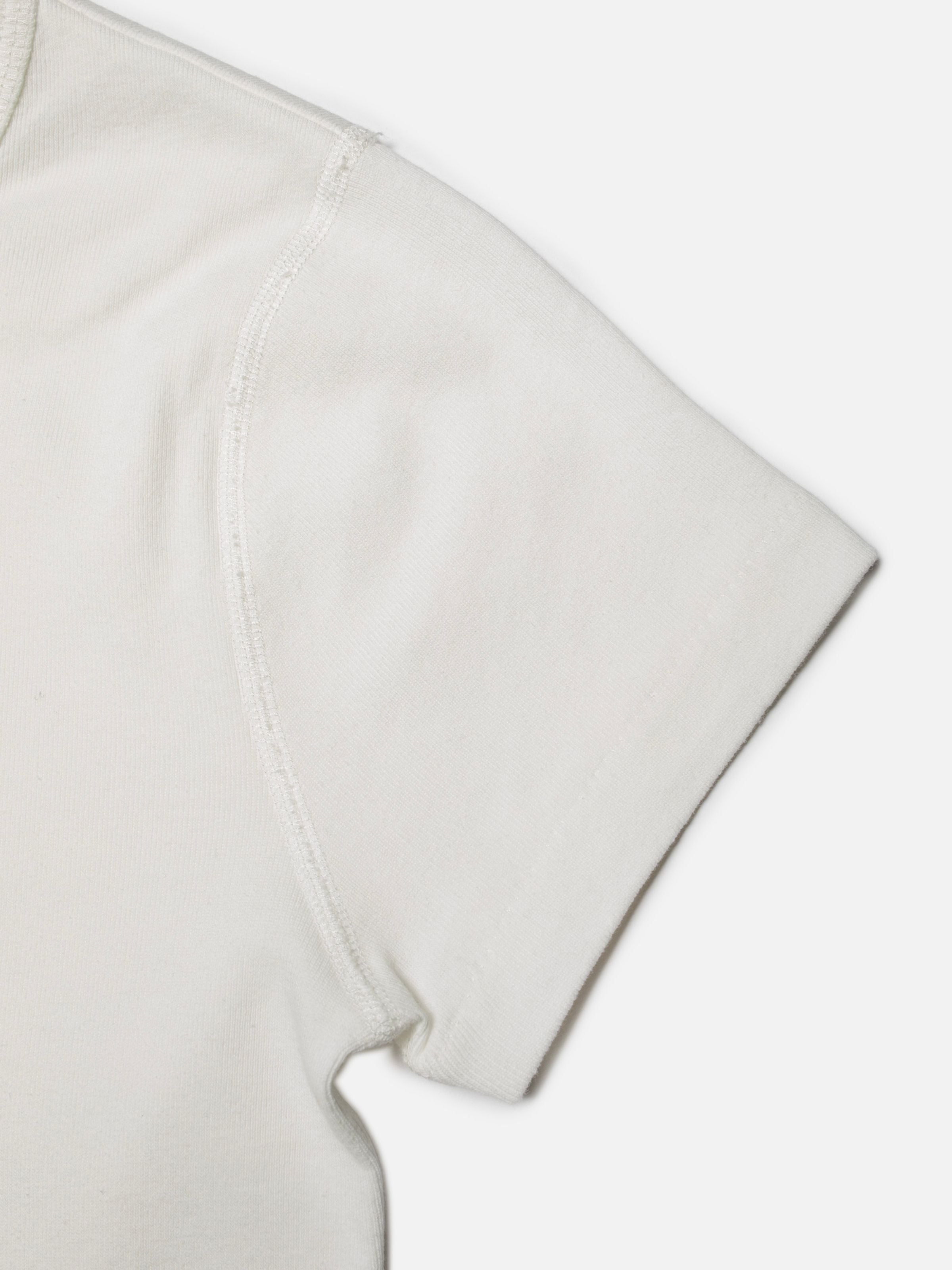 Nudie Jeans Eve T-Shirt Eyeballs in Offwhite, close-up showing the raglan sleeve and 1x1 organic cotton rib knit.