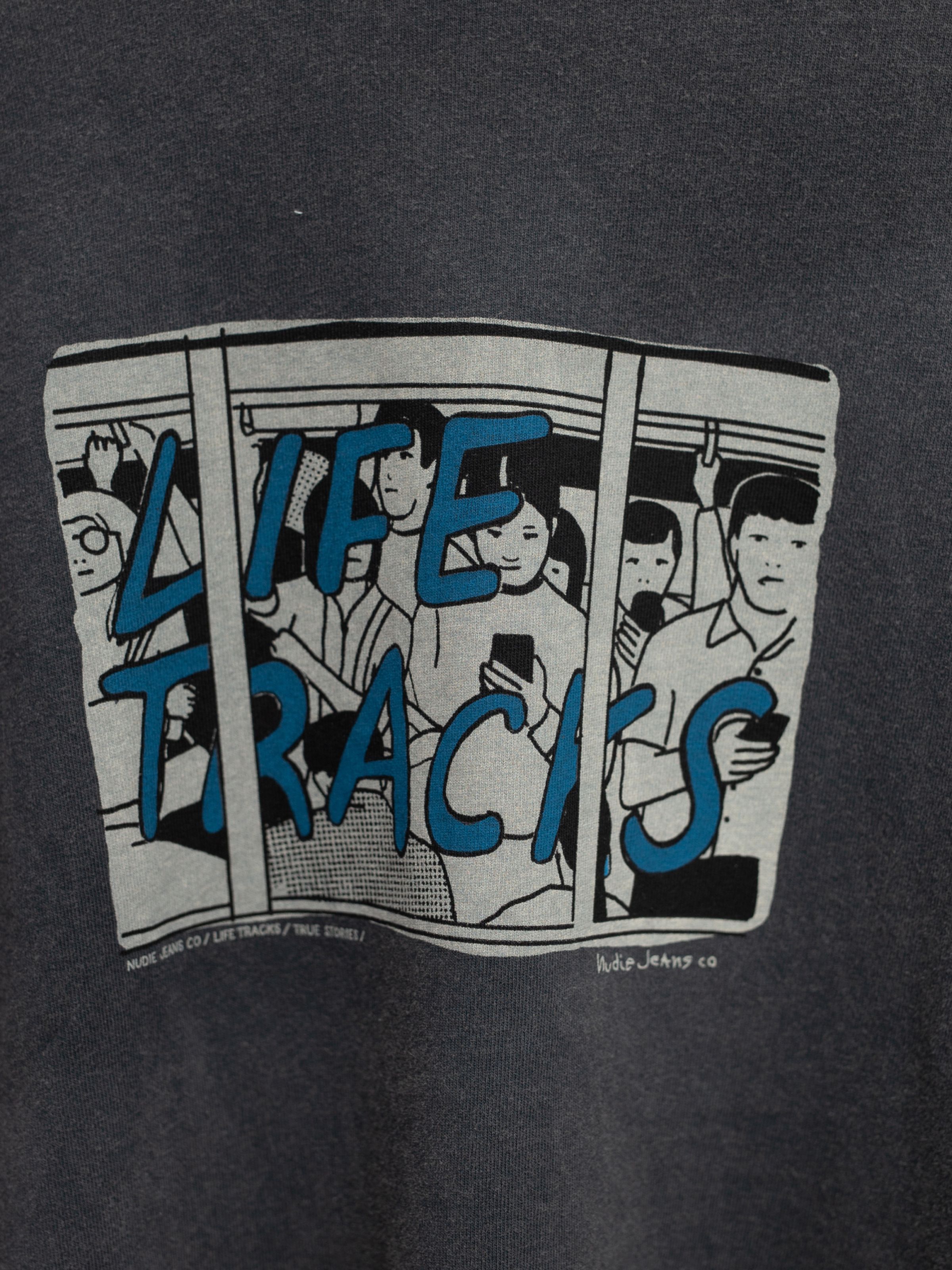 Nudie Jeans Frankie T-Shirt Life Tracks II Antracite, a close-up of the blue chest graphic on organic cotton jersey.