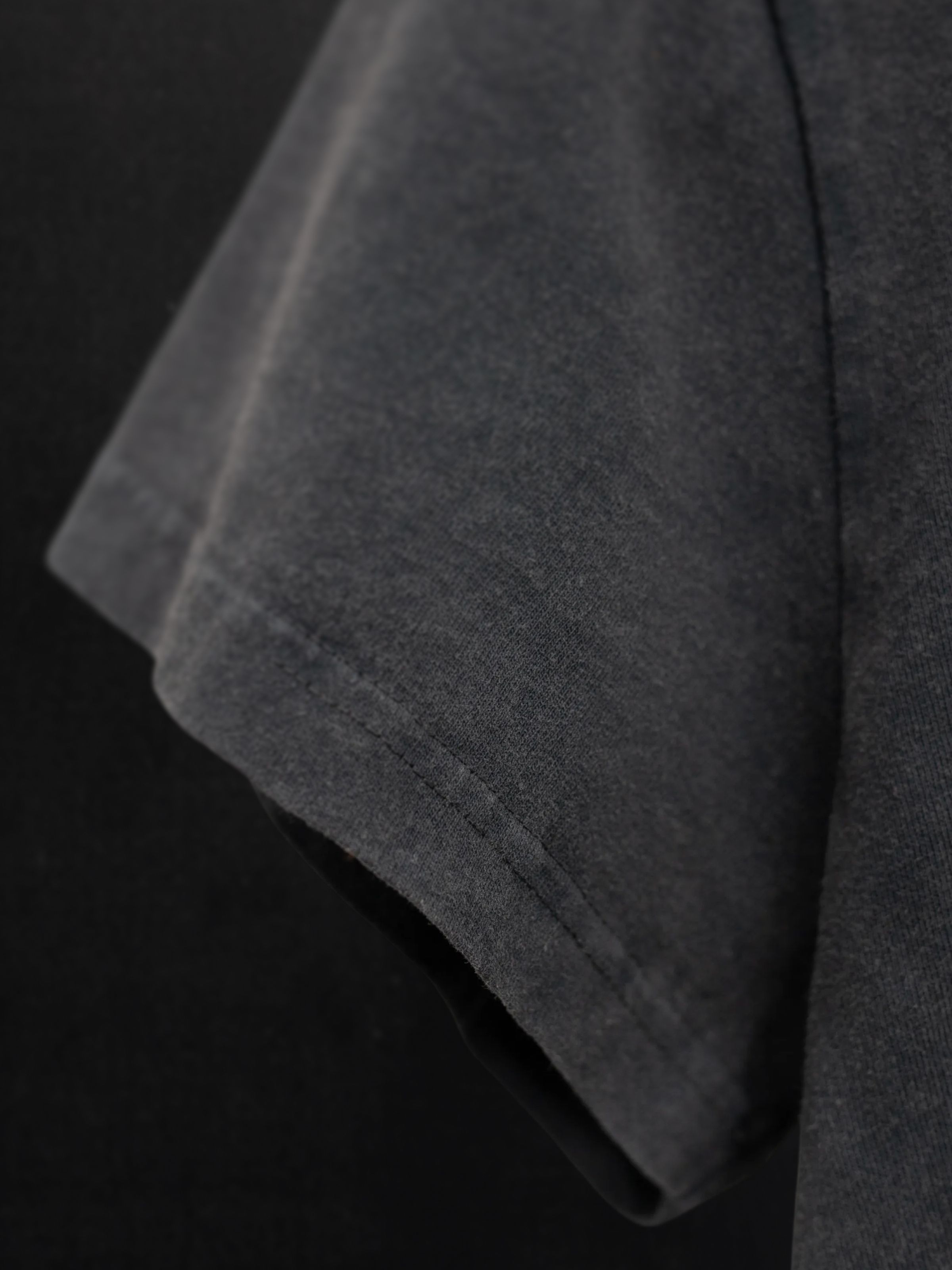 Nudie Jeans Frankie T-Shirt Life Tracks II Antracite, a close-up of the faded organic cotton jersey and sleeve stitching.