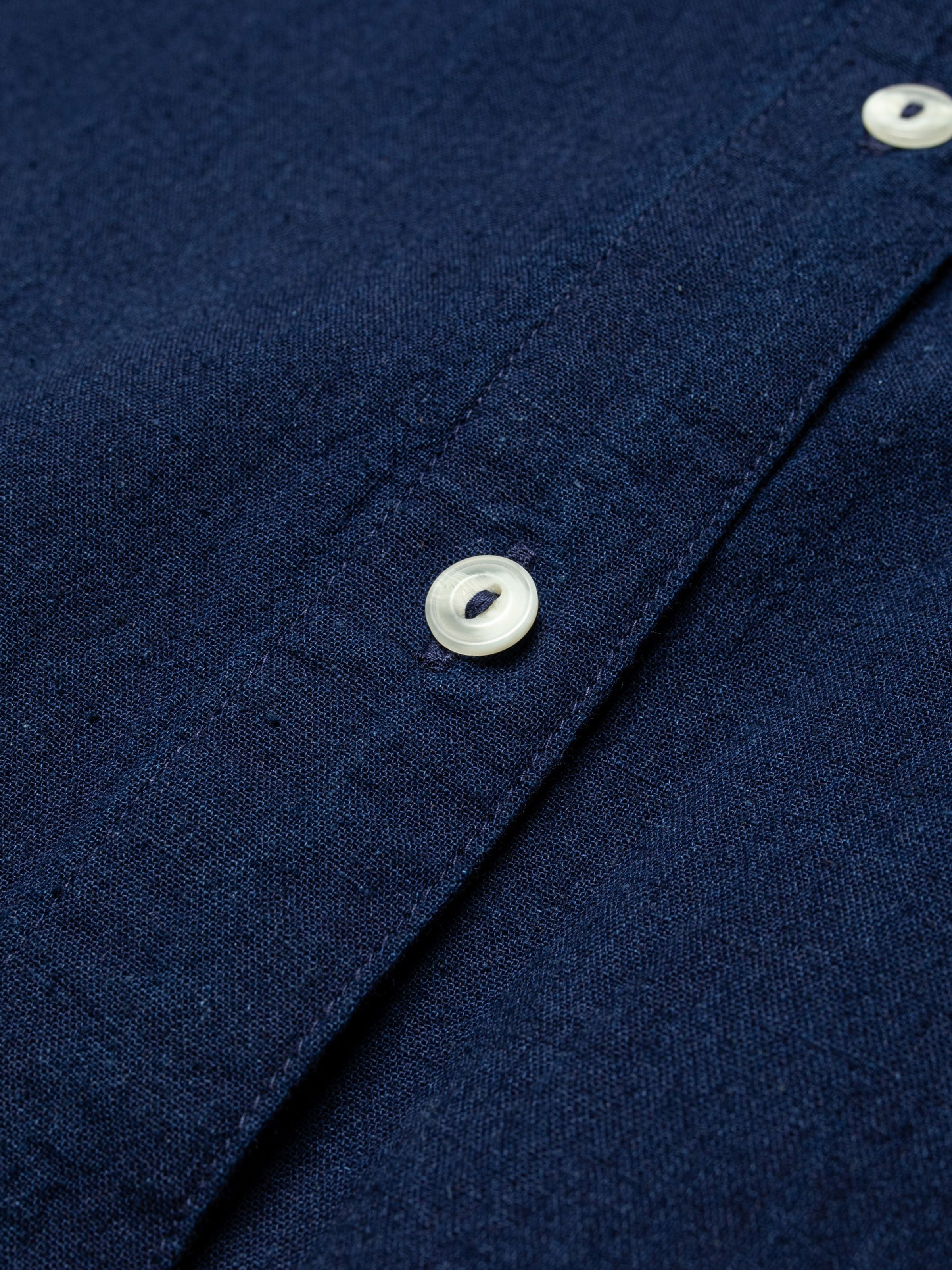 Nudie Jeans Nila Shirt Dress Indigo, close-up of a corozo button on the indigo organic cotton and organic linen blend.