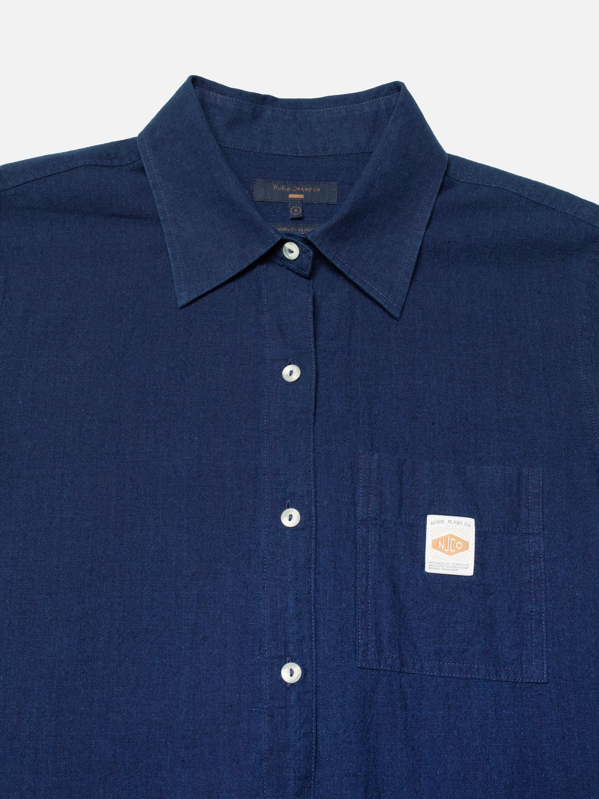 Nudie Jeans Nila Shirt Dress in Indigo Blue, close-up of the organic cotton blend fabric, buttons, and chest pocket label.