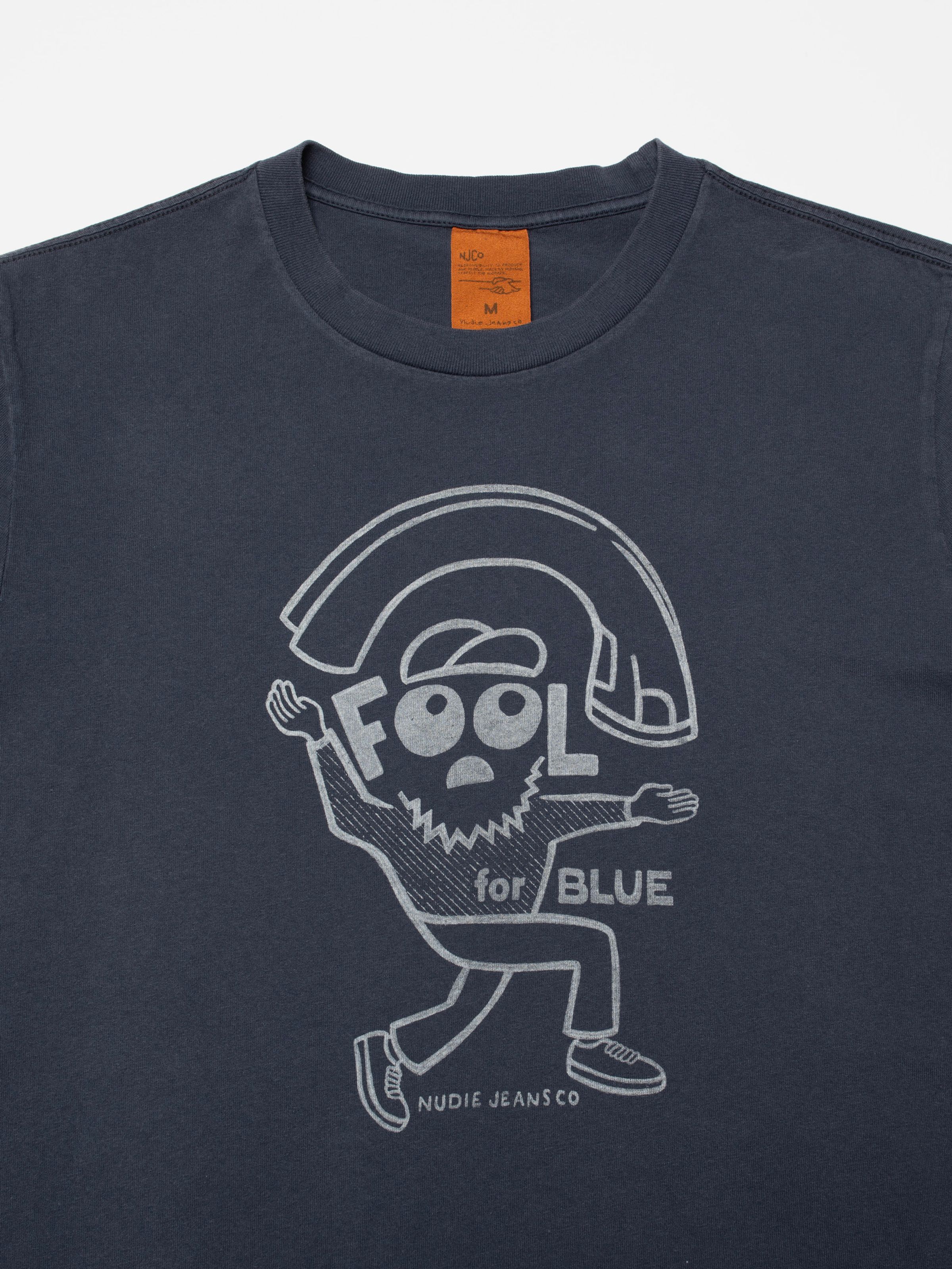 Nudie Jeans Roy T-Shirt Jeanjuggler in Dark Blue, eine Nahaufnahme des Brust-Grafikprints aus Bio-Baumwolle.