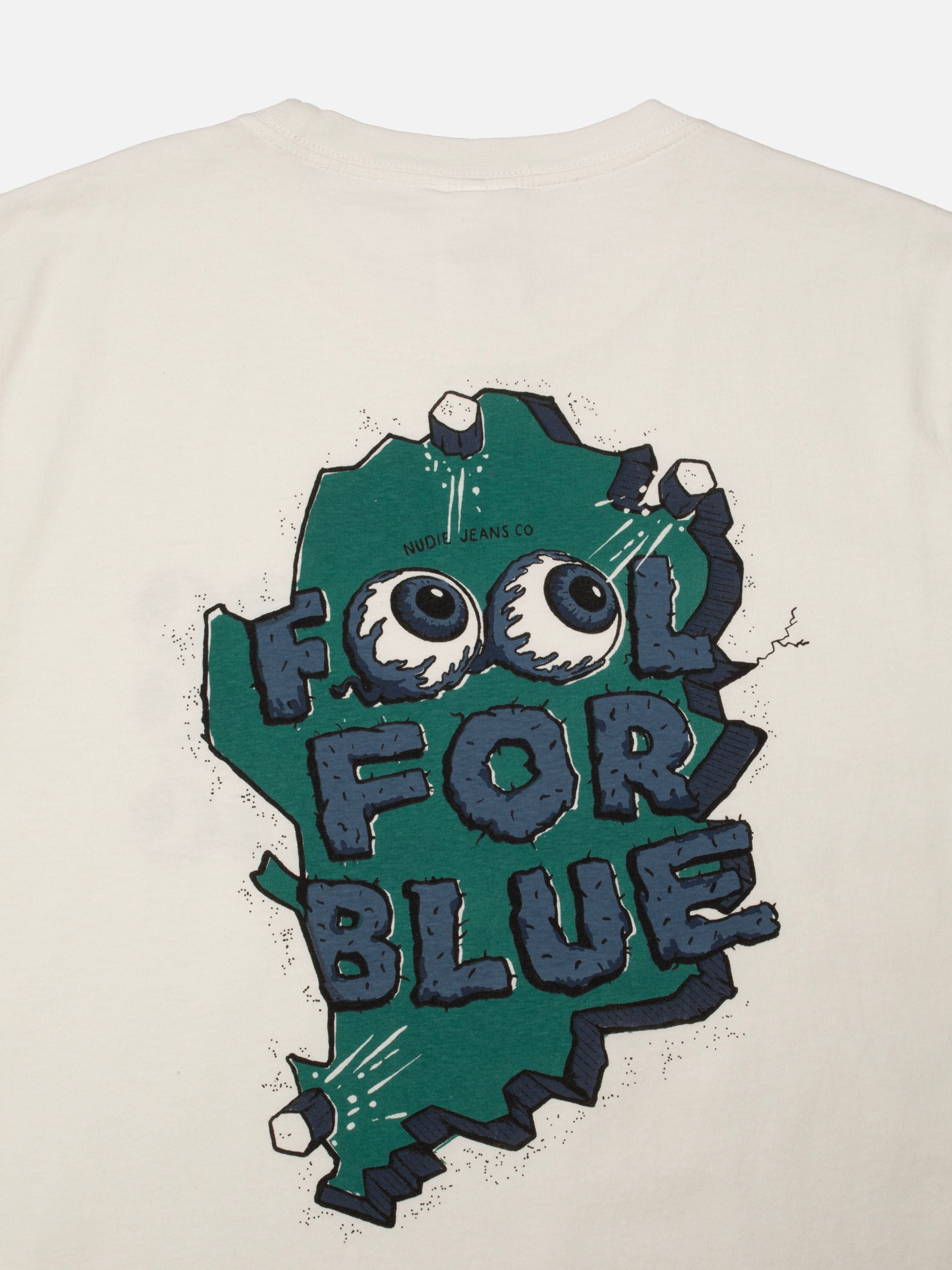 Nudie Jeans Roy T-Shirt Wall Crack Chalk White, eine Nahaufnahme des „Fool for Blue“ Grafikprints aus Bio-Baumwolle.