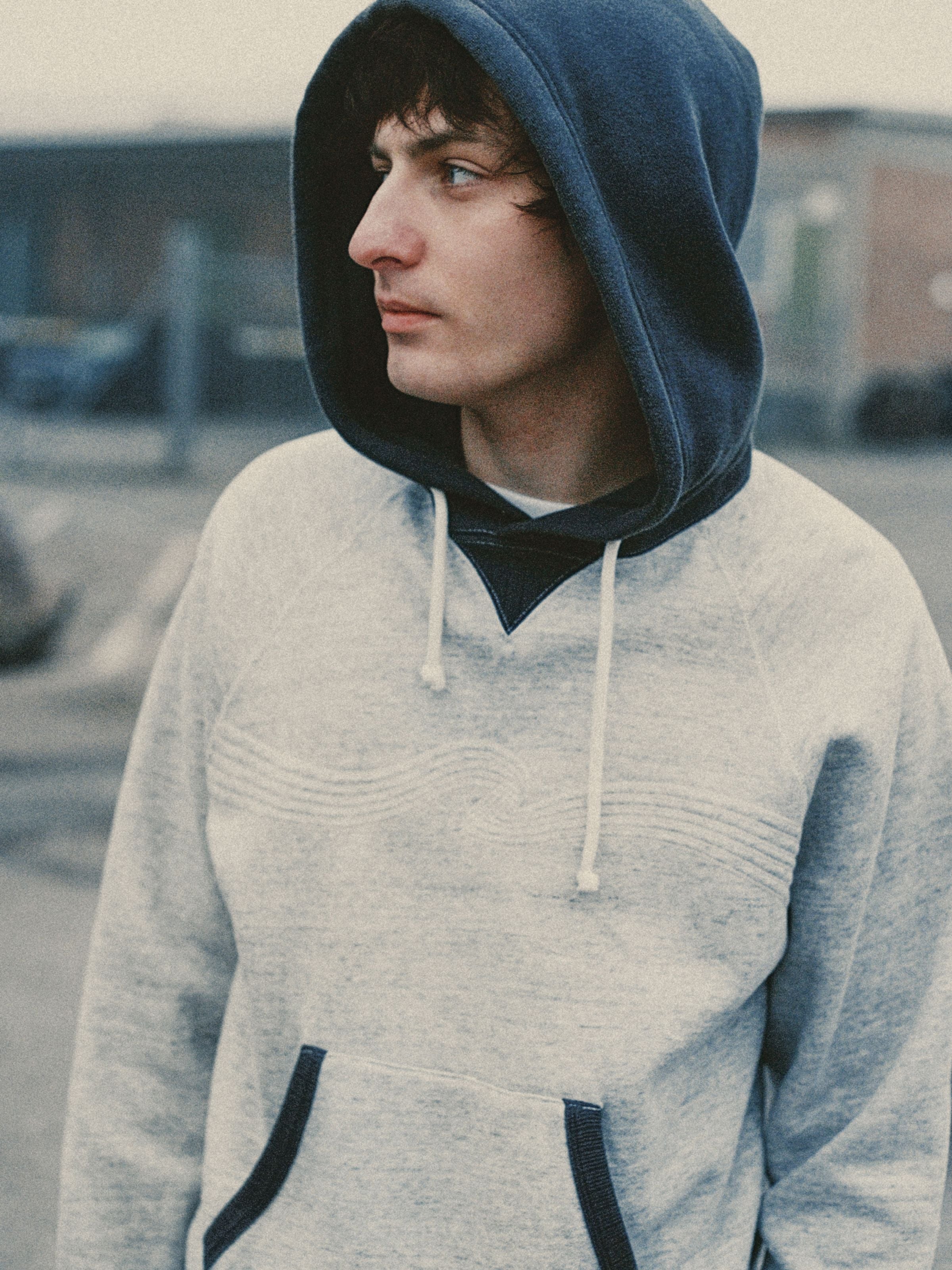 Nudie Jeans Gunde Hoodie Embo Wave in grey melange organic cotton with a contrasting blue hood and chest embroidery.