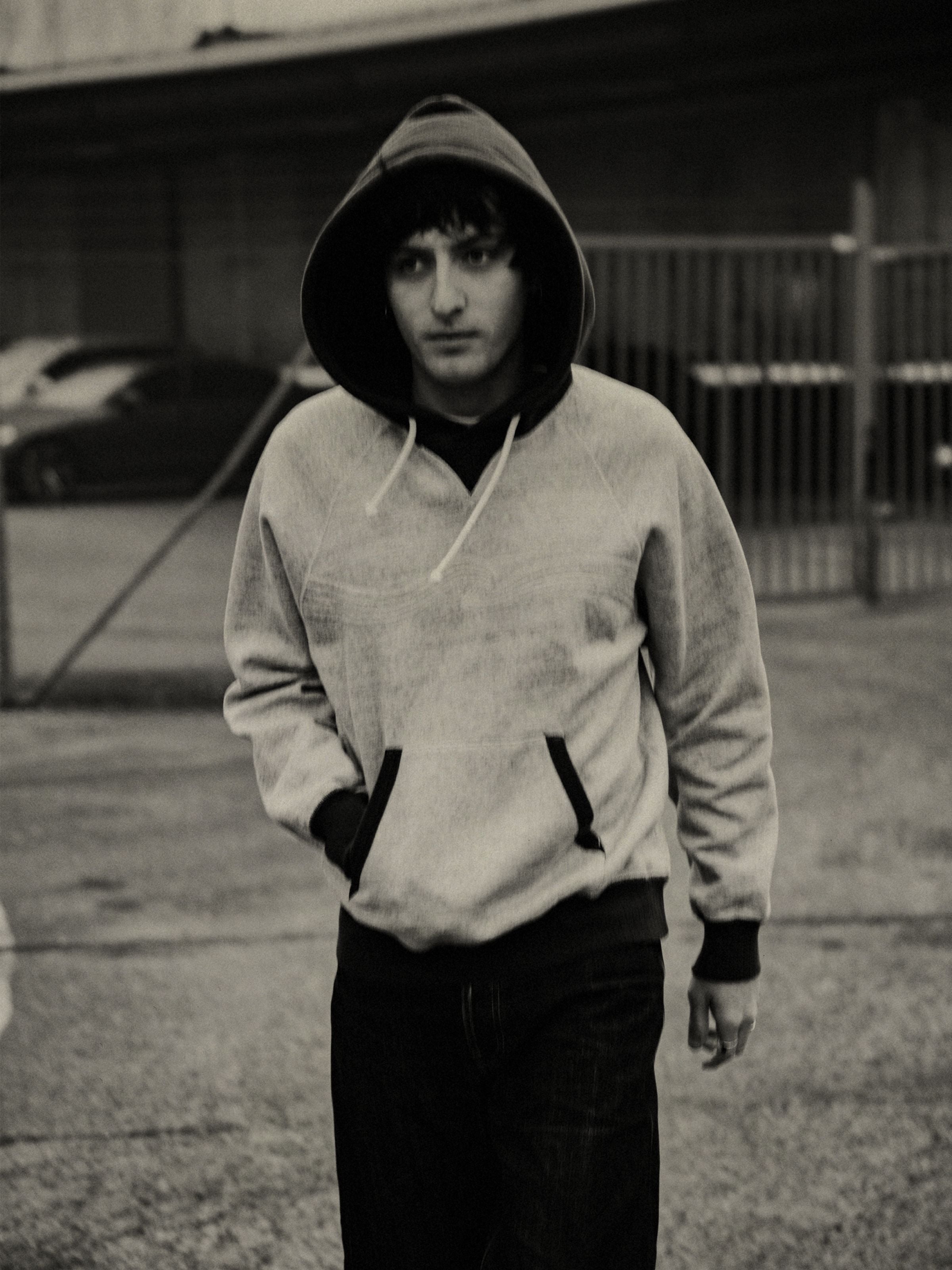 Nudie Jeans Gunde Hoodie Embo Wave Greymelange, an organic cotton sweatshirt with contrasting hood and cuffs on a model.