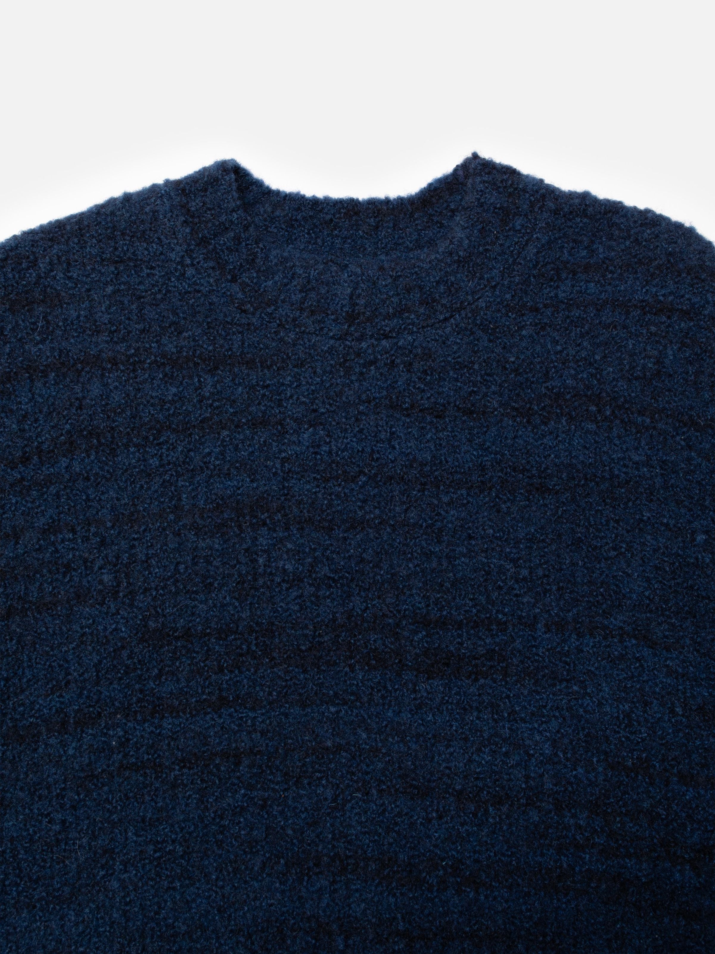 Nudie Jeans Gurra Boucle Sweater Multi, close-up of the crew neckline and textured dark blue organic wool blend fabric.