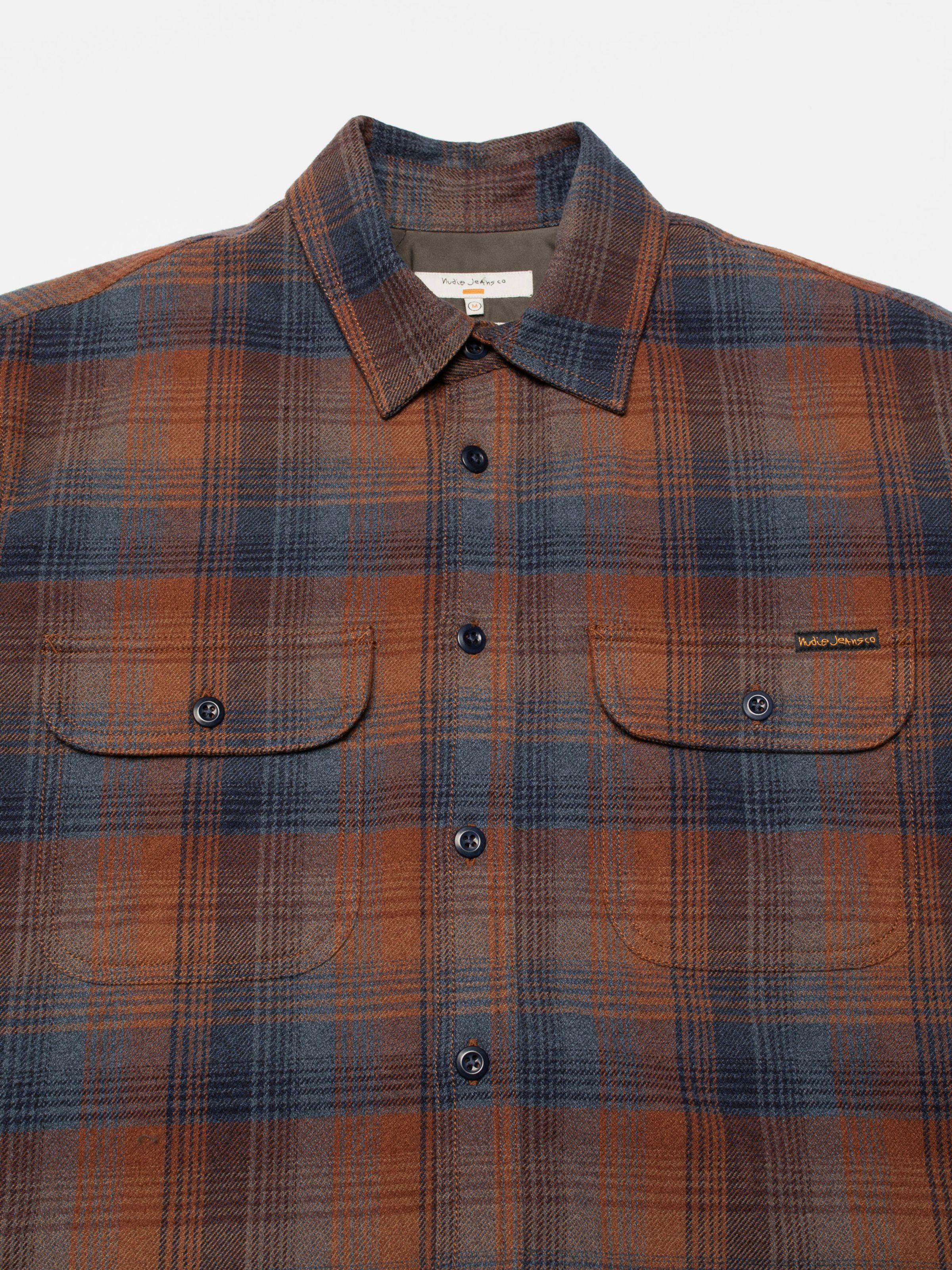 Nudie Jeans Glenn Padded Shirt Check Multi, close-up of the organic cotton padded overshirt's check pattern and pockets.