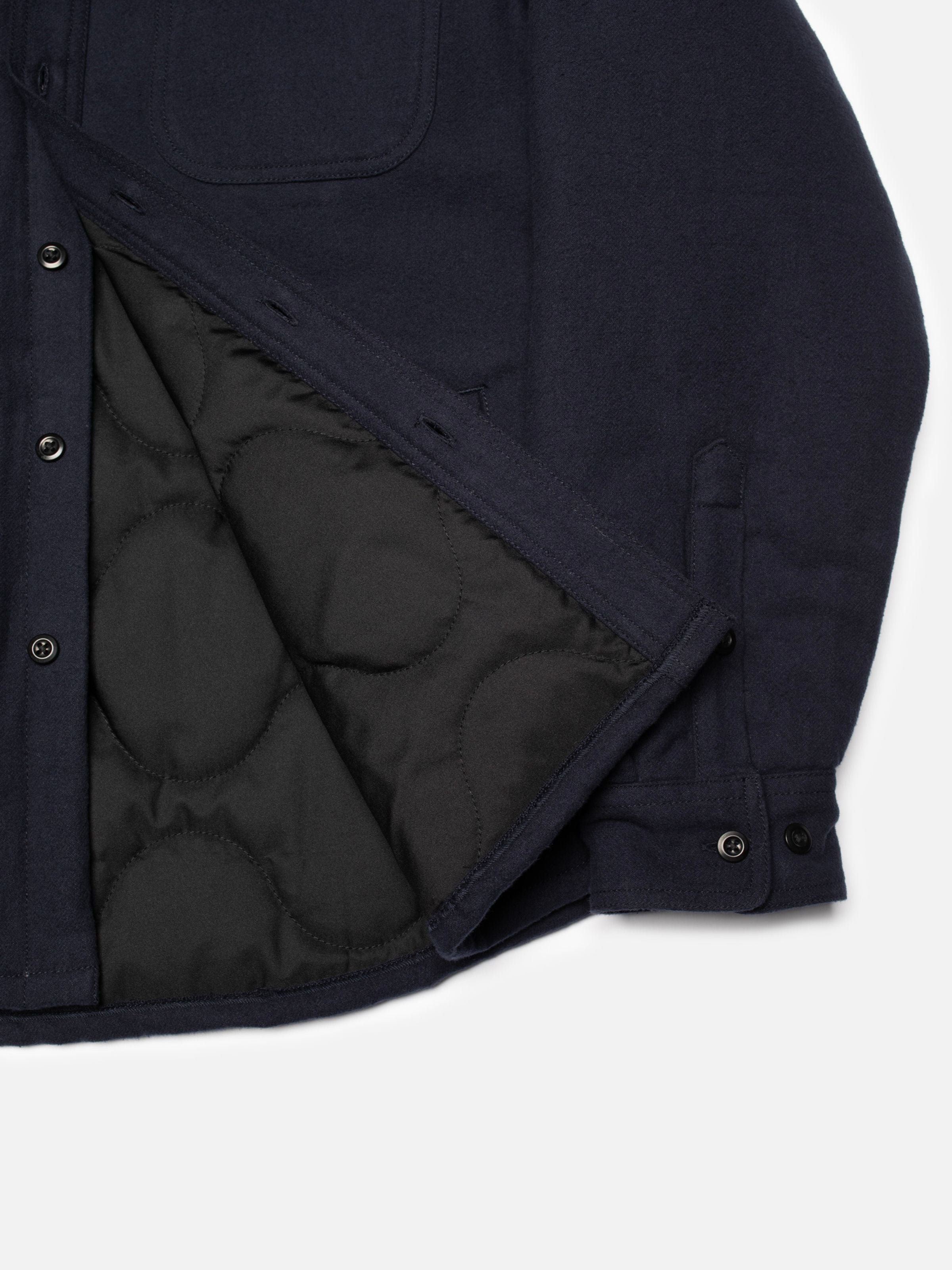 Nudie Jeans Glenn Padded Shirt Flannel in Blueberry zeigt das schwarze Steppfutter und den Flanellstoff aus Bio-Baumwolle.