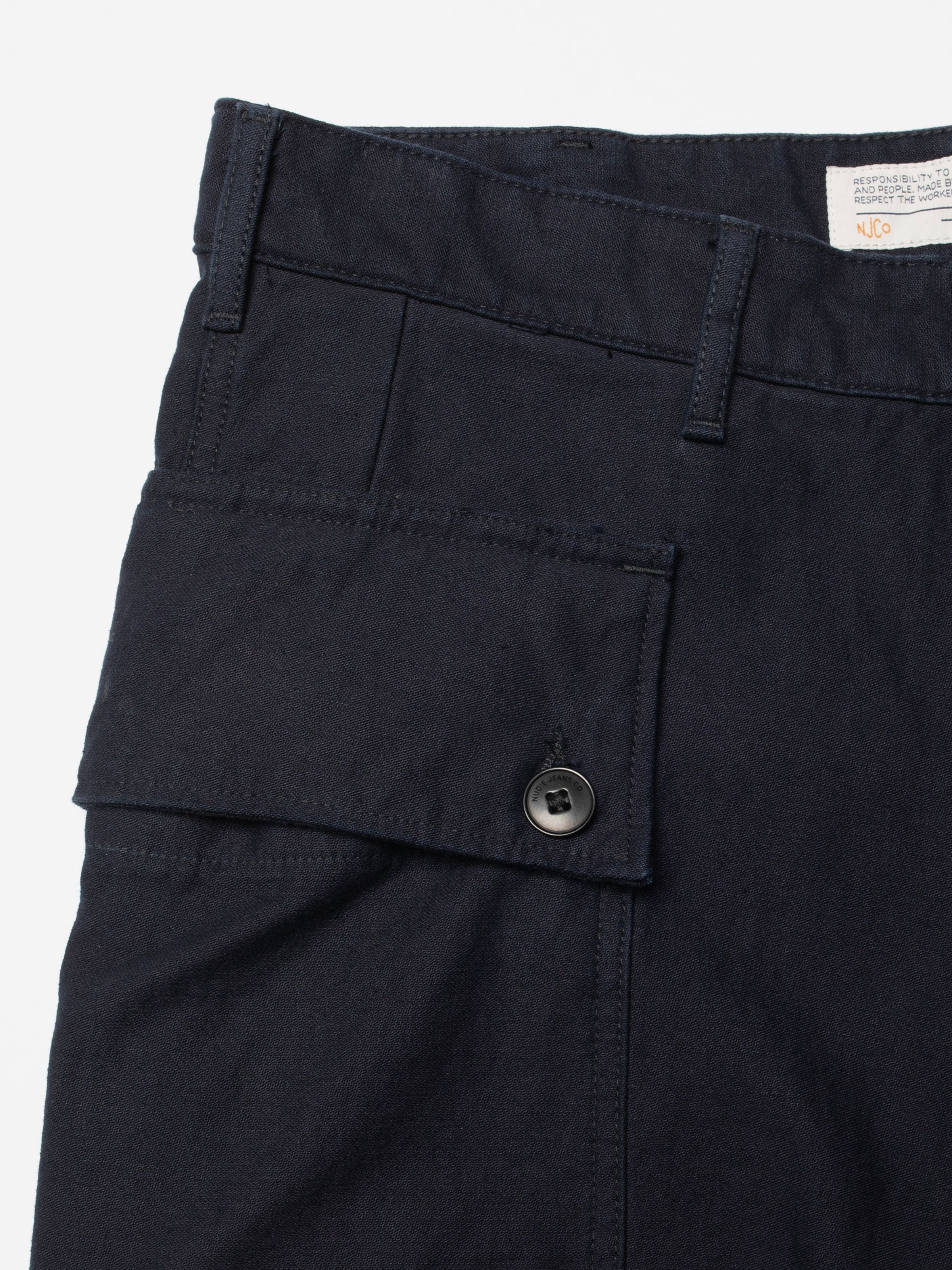 Nudie Jeans Loud Larry Pants Back Sateen in indigo organic cotton, showing a close-up of the buttoned cargo pocket.