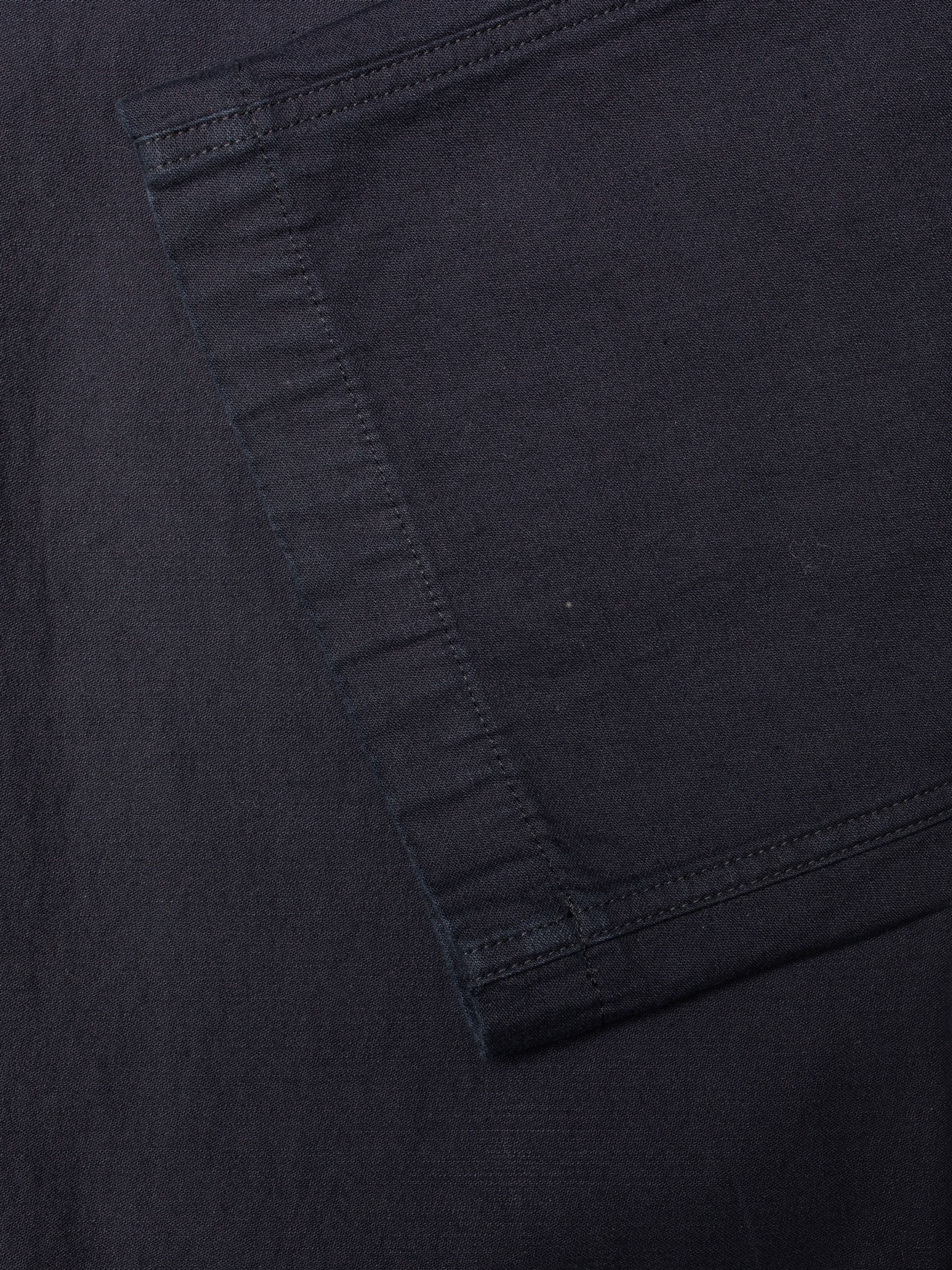 Nudie Jeans Loud Larry Pants Back Sateen, close-up of the indigo organic cotton fabric with visible slub texture.