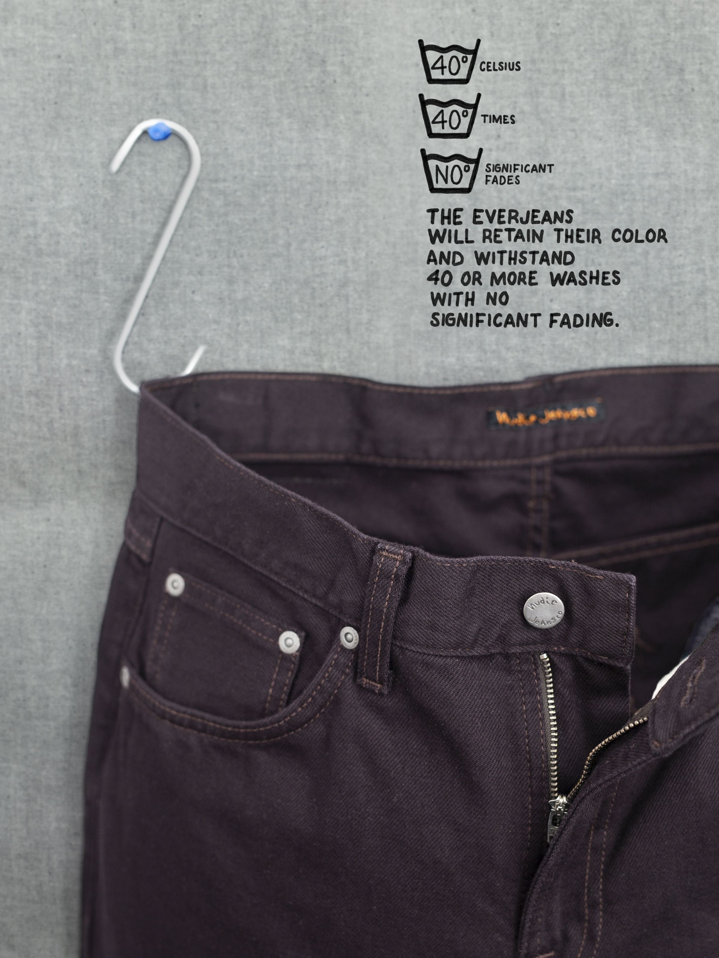 Nudie Jeans Gritty Jackson Everbrown, Nahaufnahme des Zip Fly und Bunds aus tiefbraunem Rigid Denim aus Bio-Baumwolle.