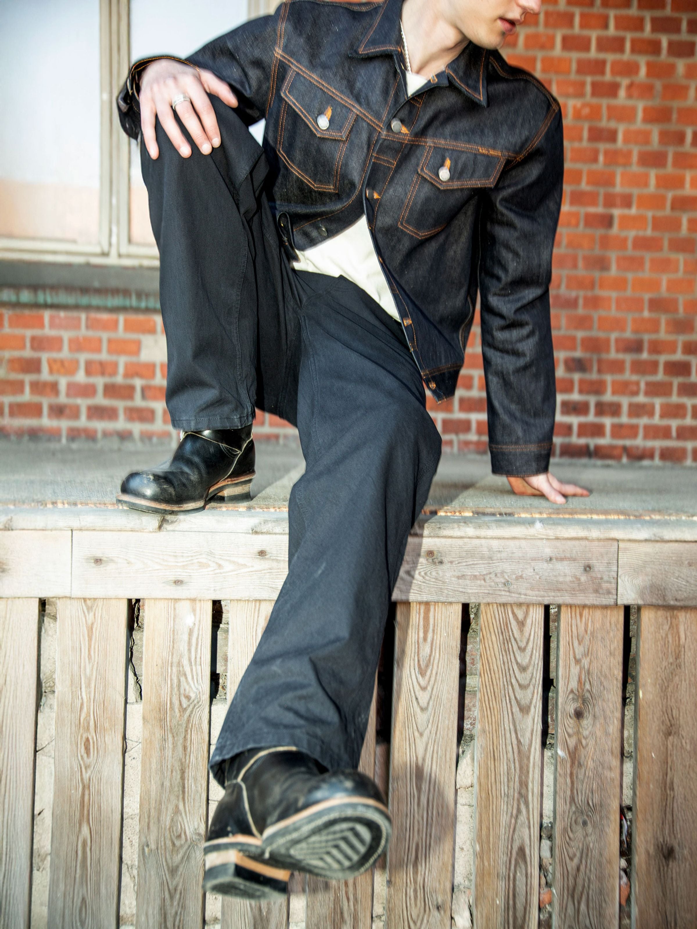 Nudie Jeans Tuff Tony Pants in black organic cotton duck canvas, loose-fit workwear pants shown in a lifestyle setting.
