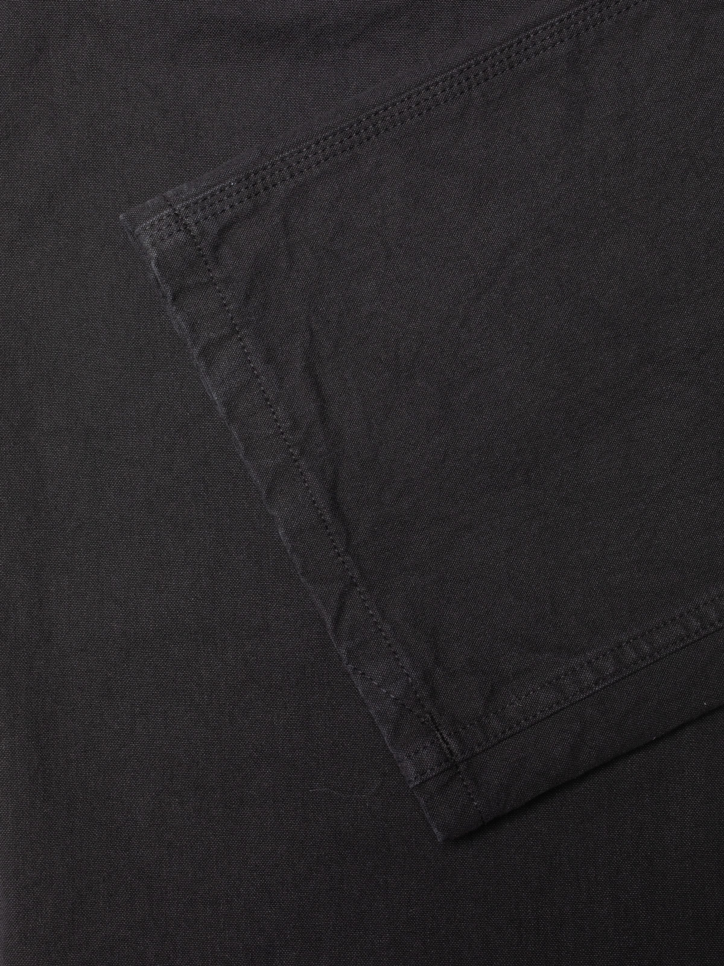 Nudie Jeans Tuff Tony Pants Duck Canvas BL, close-up of the textured black organic cotton canvas with grey stitching.
