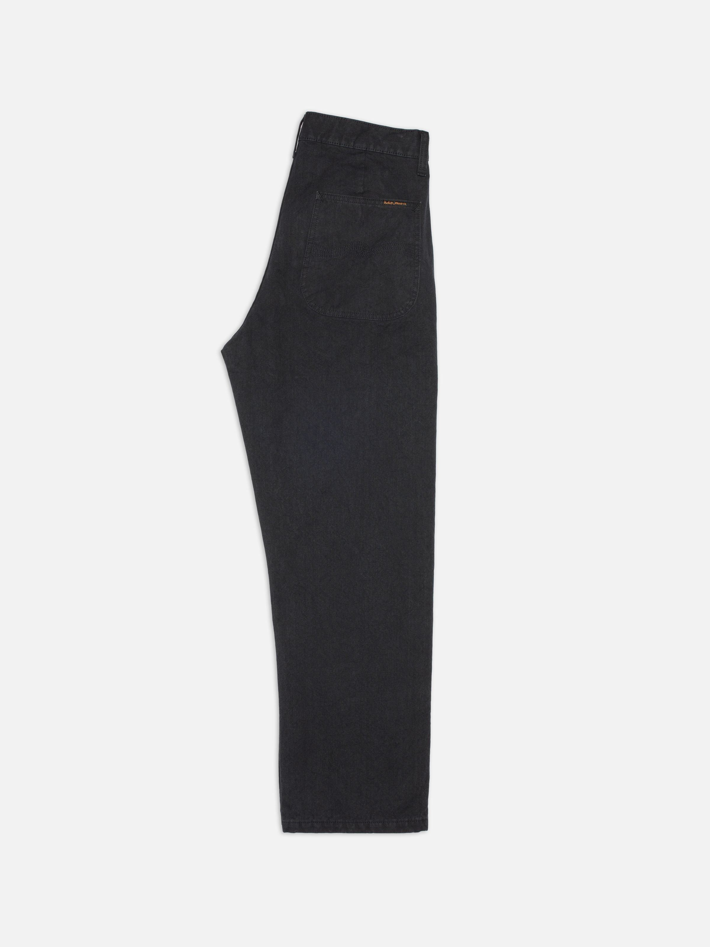 Nudie Jeans Tuff Tony Pants in black organic cotton duck canvas, featuring a loose fit and wide leg in a side profile.