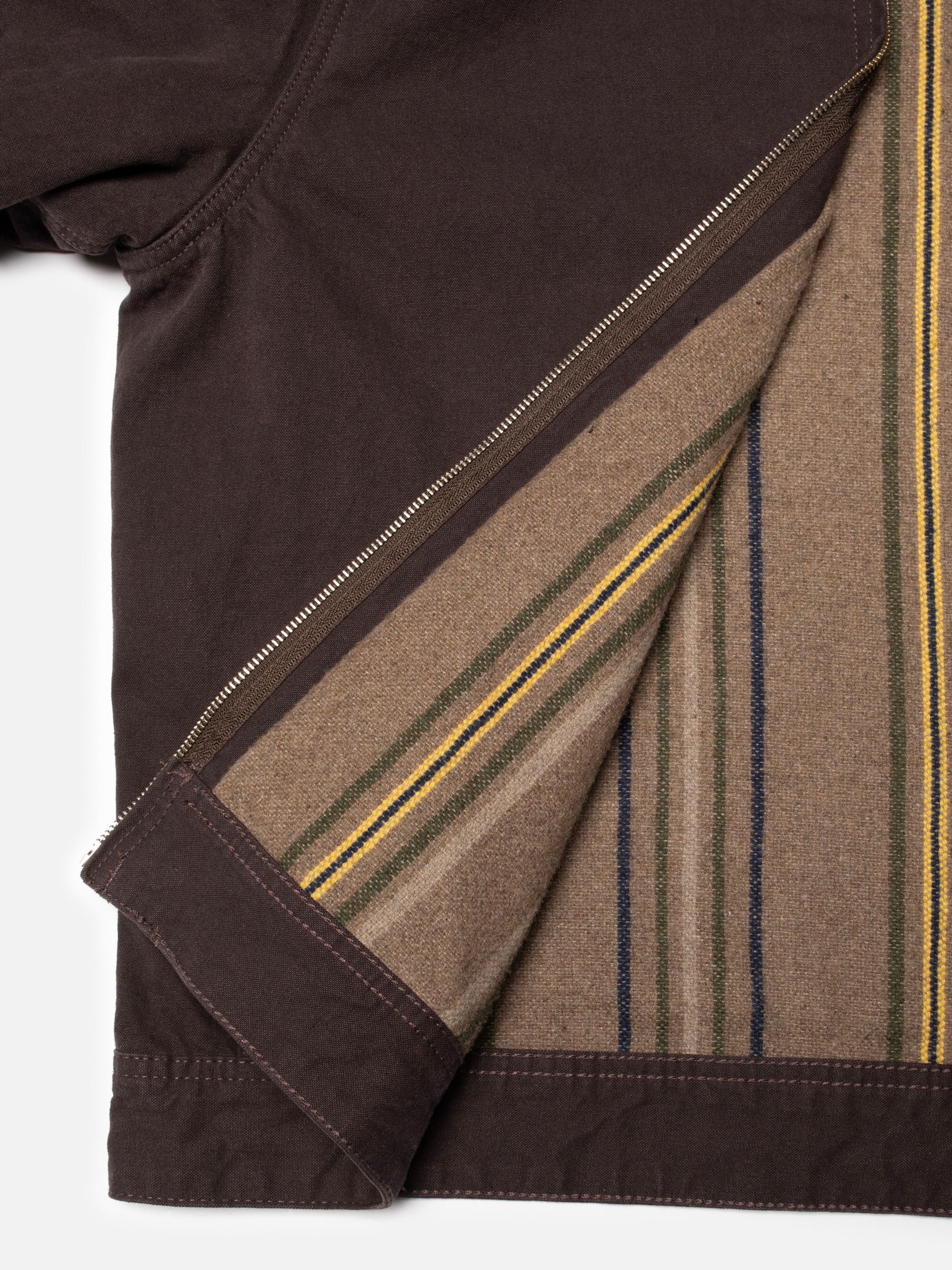 Nudie Jeans Blake Zip Jacket in Dunkelbraun aus Bio-Baumwolle Duck-Canvas zeigt das gestreifte Wollmischfutter.