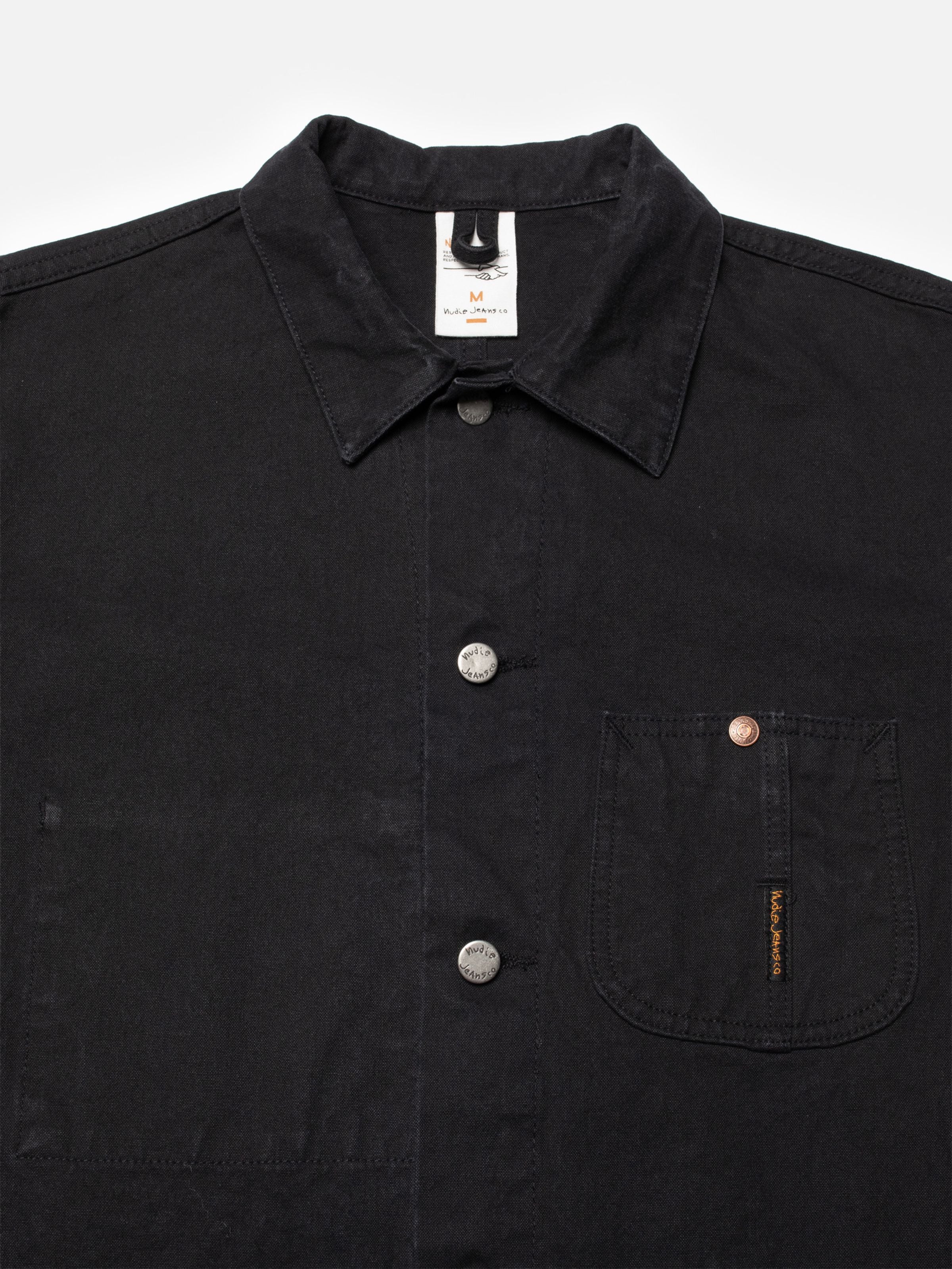 Nudie Jeans Howie Chore Jacket aus schwarzer Bio-Baumwolle (Duck-Canvas), mit antiken Silberknöpfen und Brusttasche.