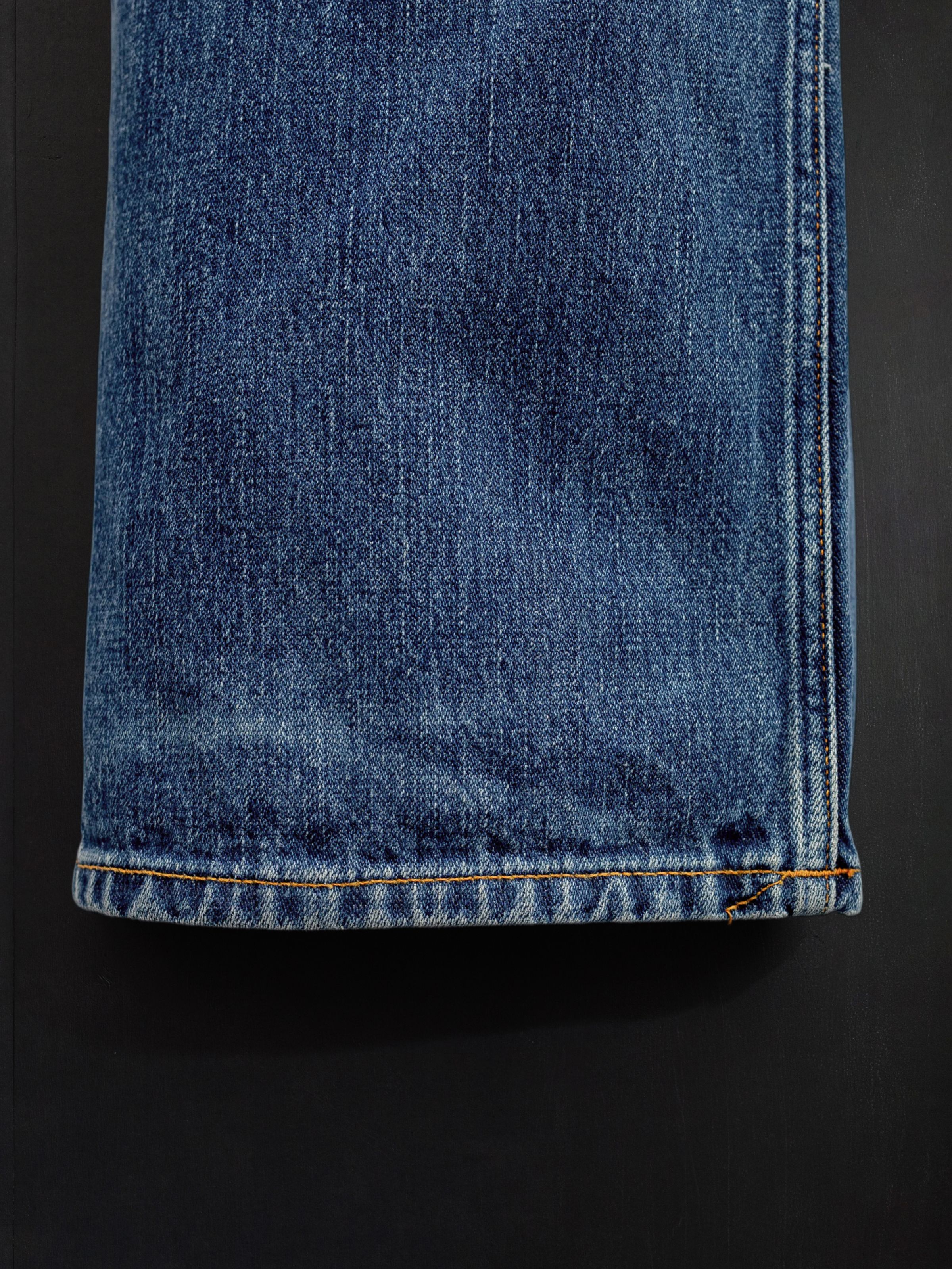 Nudie Jeans Loud Larry Muted Tracks, men's loose fit jeans, showing a close-up of the hem and fabric texture.