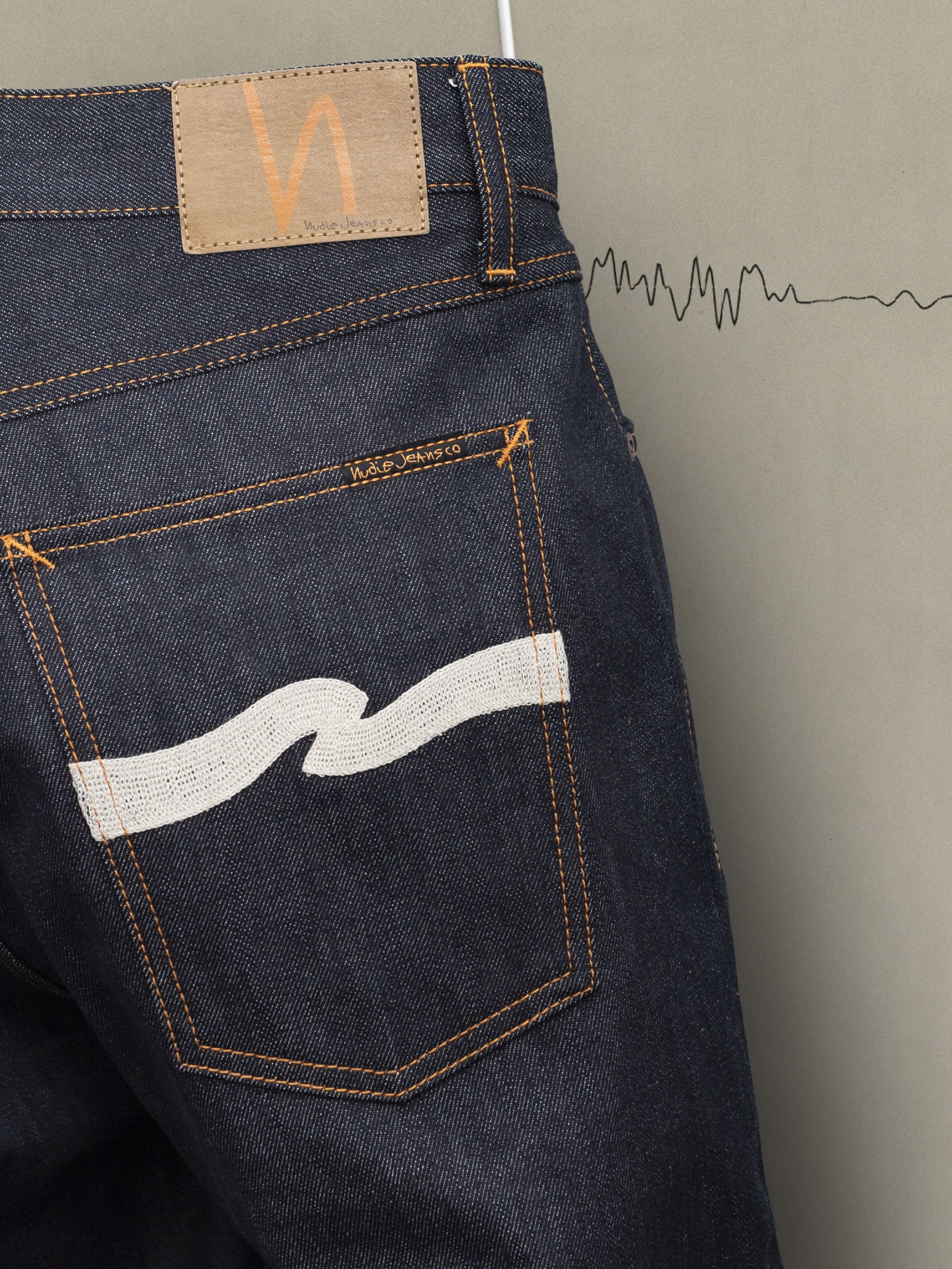 Nudie Jeans Tuff Tony Dry Ecru Waves mit Ecru-Stickerei auf der Gesäßtasche aus dunkelblauem Rigid-Denim aus Bio-Baumwolle.
