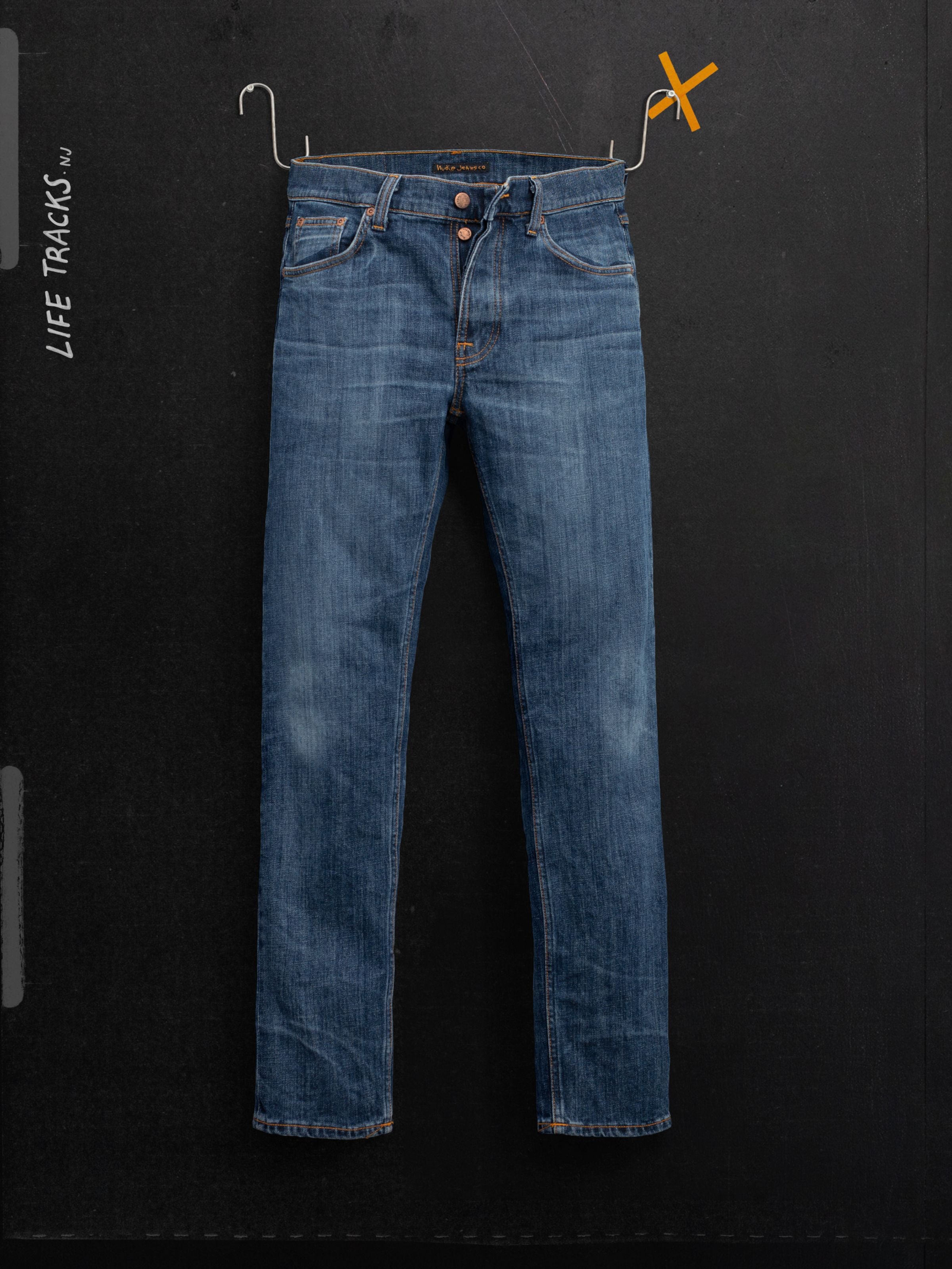 Nudie Jeans Solid Ollie Blue Echo Tracks, slim fit jeans in faded blue organic cotton comfort stretch denim shown hanging.